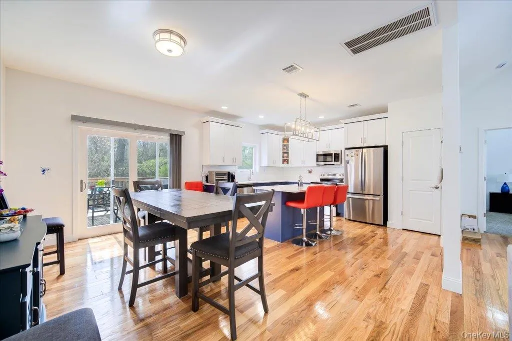 Open-concept kitchen and dining area featuring hardwood flooring Open-concept kitchen and dining area featuring hardwood flooring