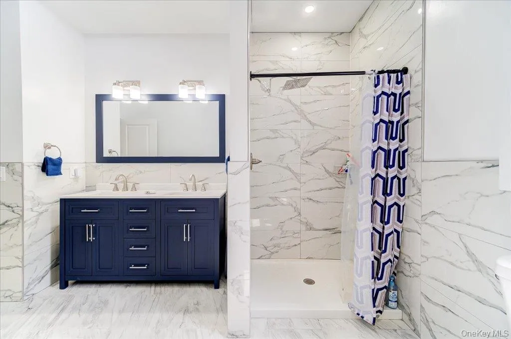 Dual vanity with a deep blue cabinet, contemporary hardware, and a framed mirror Dual vanity with a deep blue cabinet, contemporary hardware, and a framed mirror