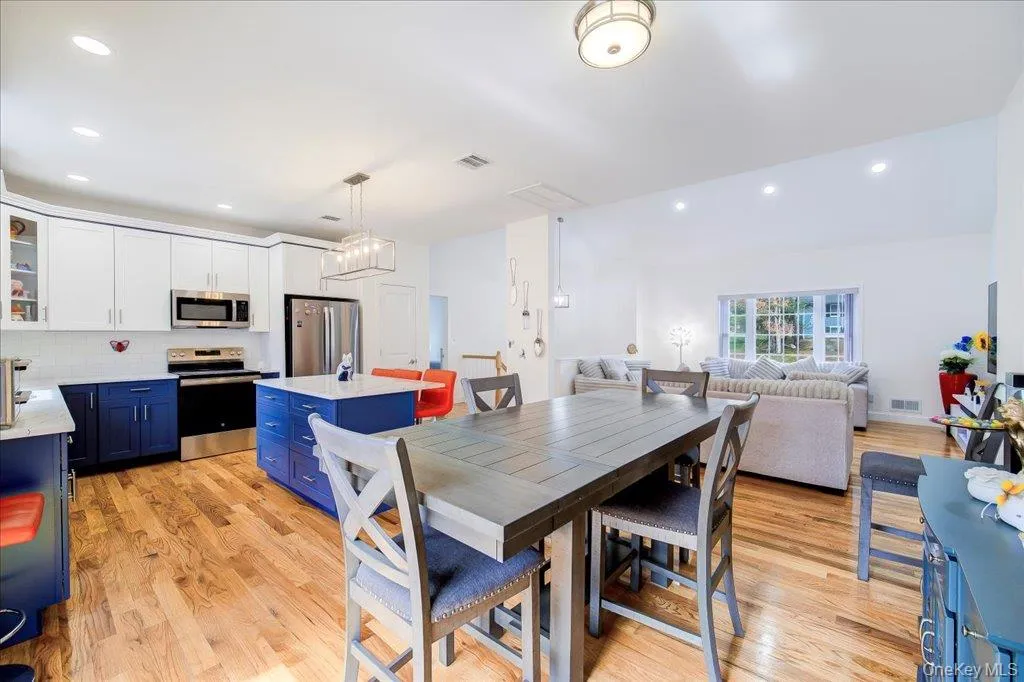 Open-concept kitchen and dining area featuring wood-finish flooring Open-concept kitchen and dining area featuring wood-finish flooring
