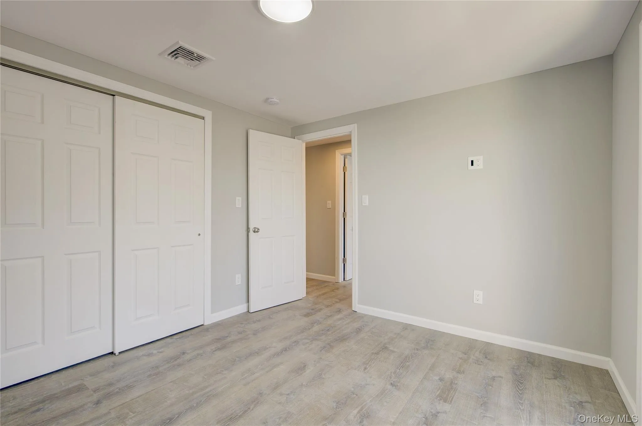Unfurnished bedroom with a closet, baseboards, visible vents, and light wood finished floors Unfurnished bedroom with a closet, baseboards, visible vents, and light wood finished floors