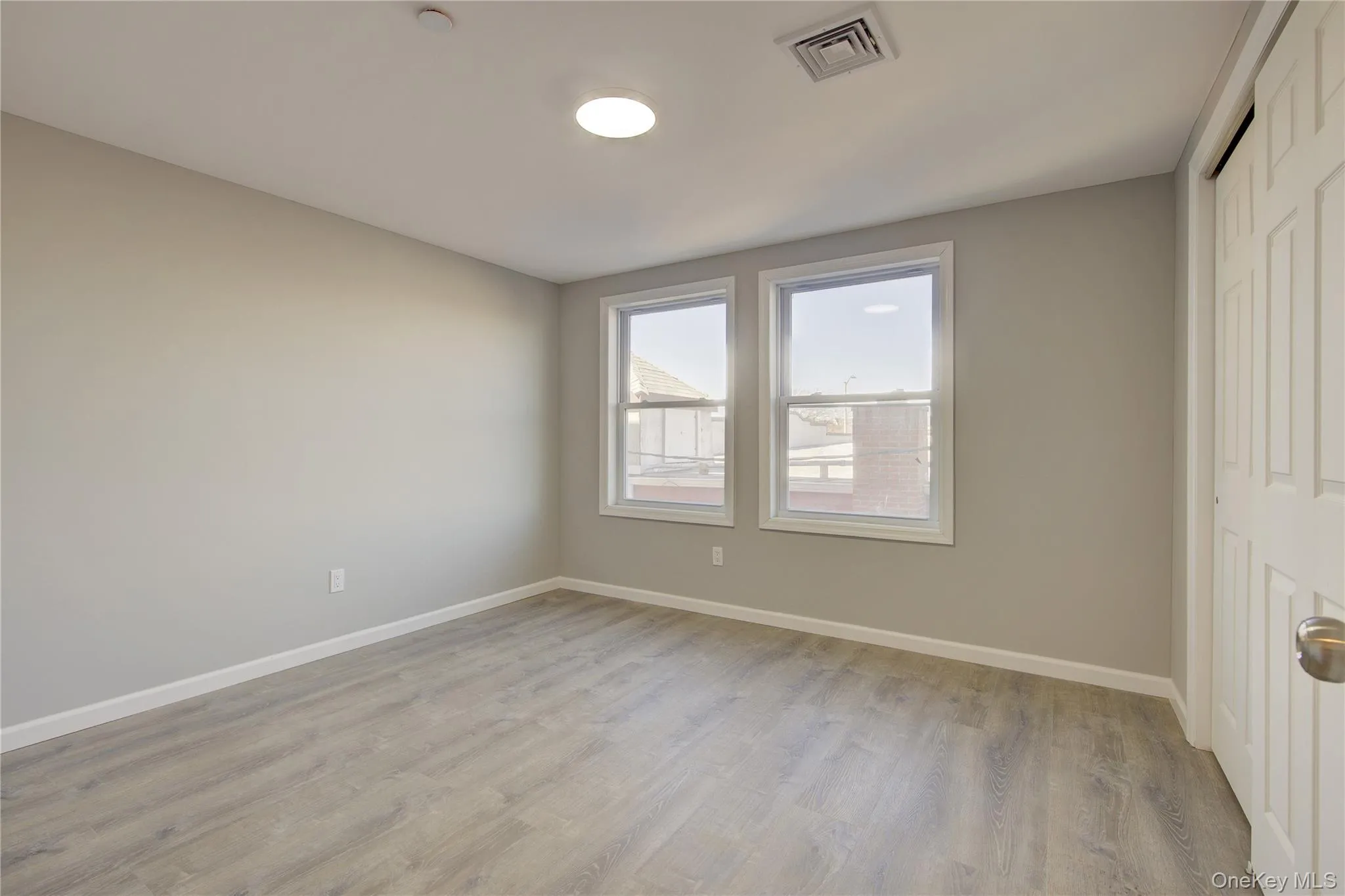 Unfurnished bedroom with light wood finished floors, baseboards, visible vents, and a closet Unfurnished bedroom with light wood finished floors, baseboards, visible vents, and a closet