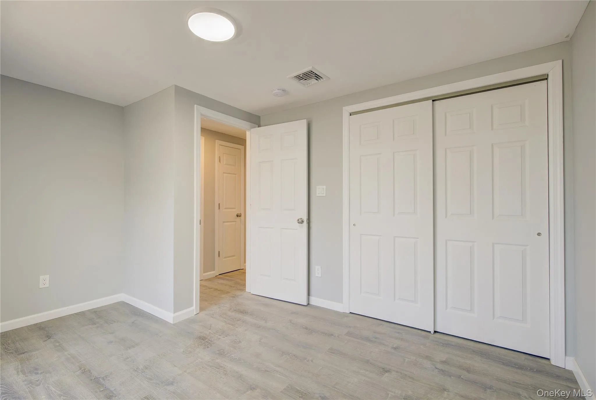 Unfurnished bedroom featuring light wood-style floors, visible vents, and baseboards Unfurnished bedroom featuring light wood-style floors, visible vents, and baseboards