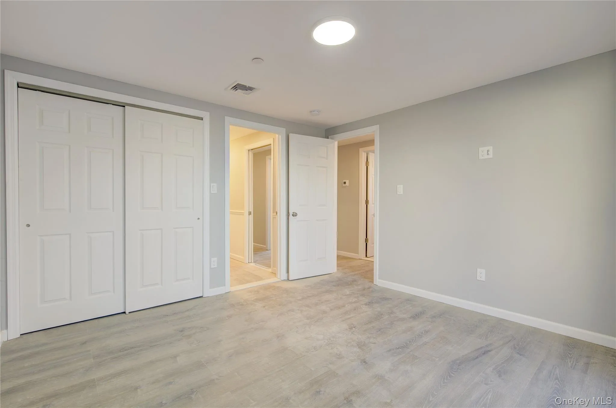 Unfurnished bedroom featuring visible vents, baseboards, a closet, and light wood finished floors Unfurnished bedroom featuring visible vents, baseboards, a closet, and light wood finished floors