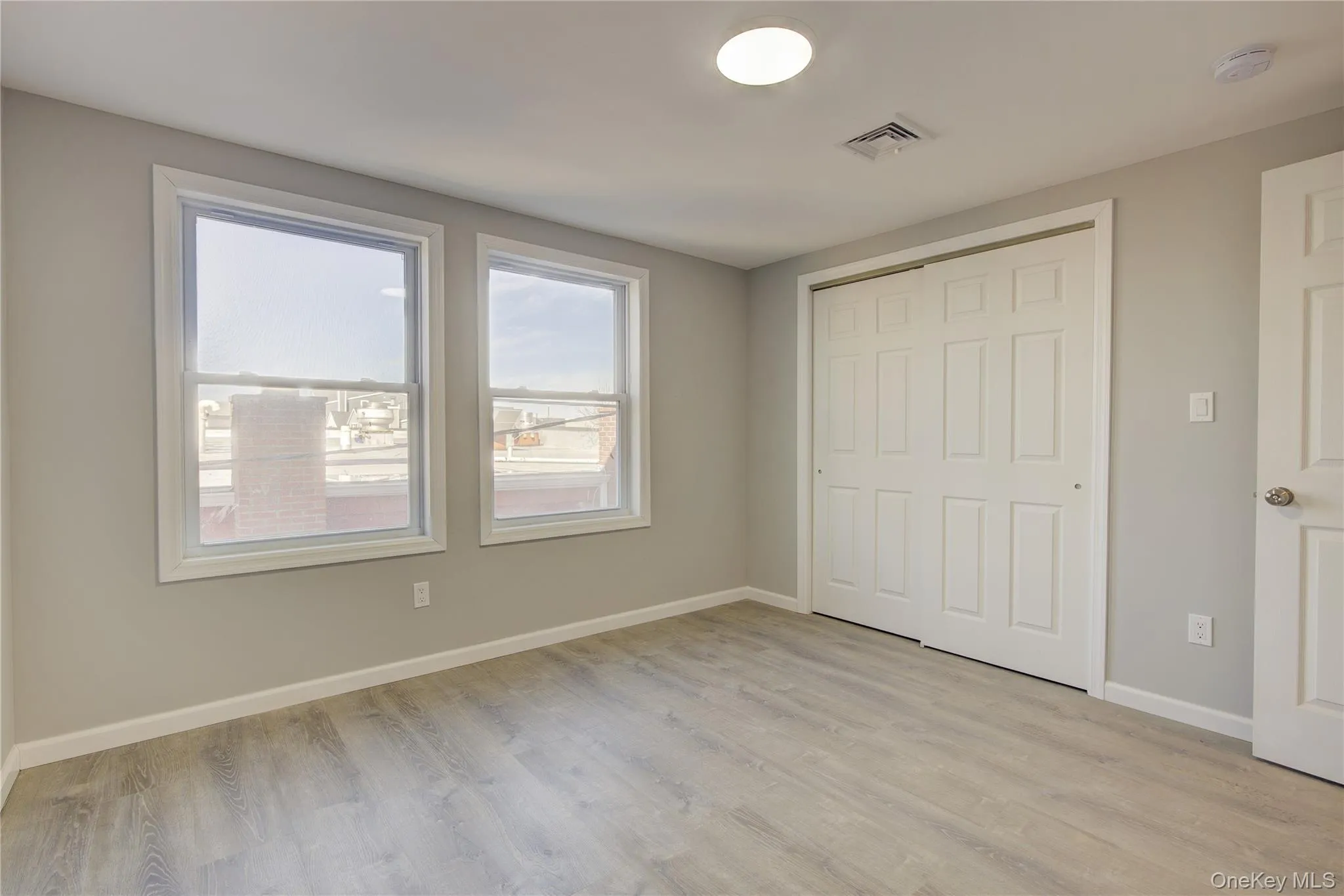 Unfurnished bedroom with a closet, visible vents, light wood-type flooring, and baseboards Unfurnished bedroom with a closet, visible vents, light wood-type flooring, and baseboards