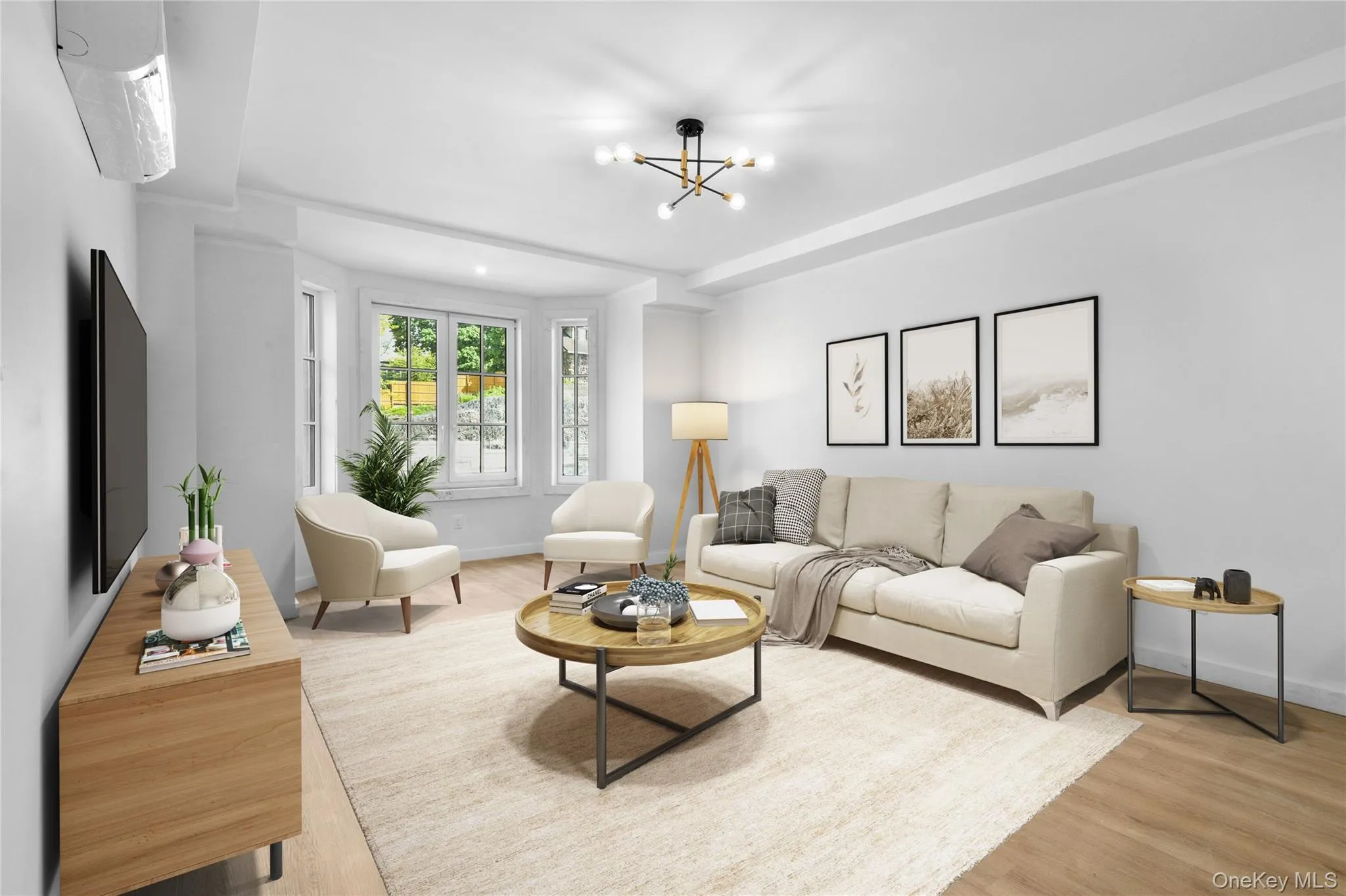 Living room featuring a notable chandelier, baseboards, and wood finished floors Living room featuring a notable chandelier, baseboards, and wood finished floors