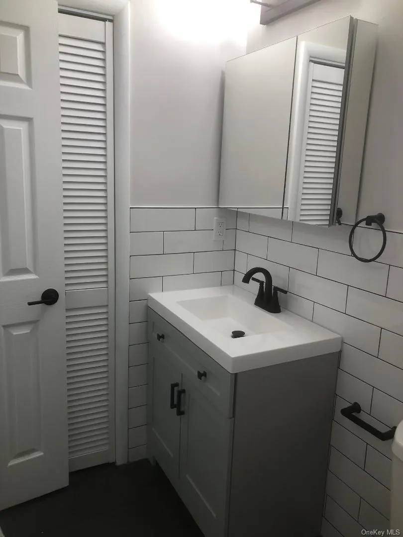 Pretty updated bathroom which features a vanity featuring a light gray shaker-style cabinet, integrated sink, and matte black hardware Pretty updated bathroom which features a vanity featuring a light gray shaker-style cabinet, integrated sink, and matte black hardware