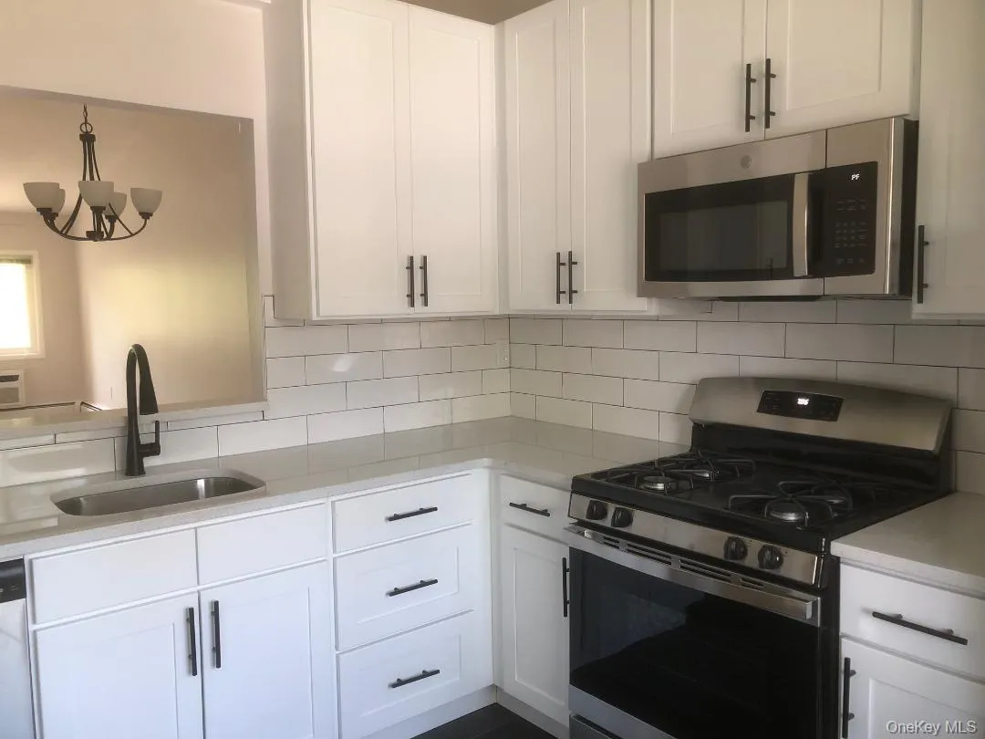 Beautifully just renovated eat in kitchen featuring lots white shaker cabinetry with dark hardware, quartz counters, stainless steel appliances, subway tile backsplash, and pretty tile floor. Beautifully just renovated eat in kitchen featuring lots white shaker cabinetry with dark hardware, quartz counters, stainless steel appliances, subway tile backsplash, and pretty tile floor.