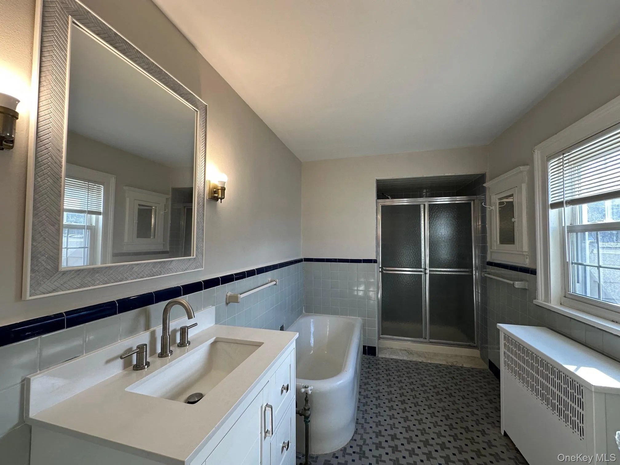 Bathroom featuring a stall shower, radiator, a garden tub, and vanity Bathroom featuring a stall shower, radiator, a garden tub, and vanity