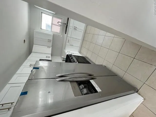 Kitchen featuring white cabinetry, light-colored countertops, stainless steel appliances, and tiled flooring Kitchen featuring white cabinetry, light-colored countertops, stainless steel appliances, and tiled flooring