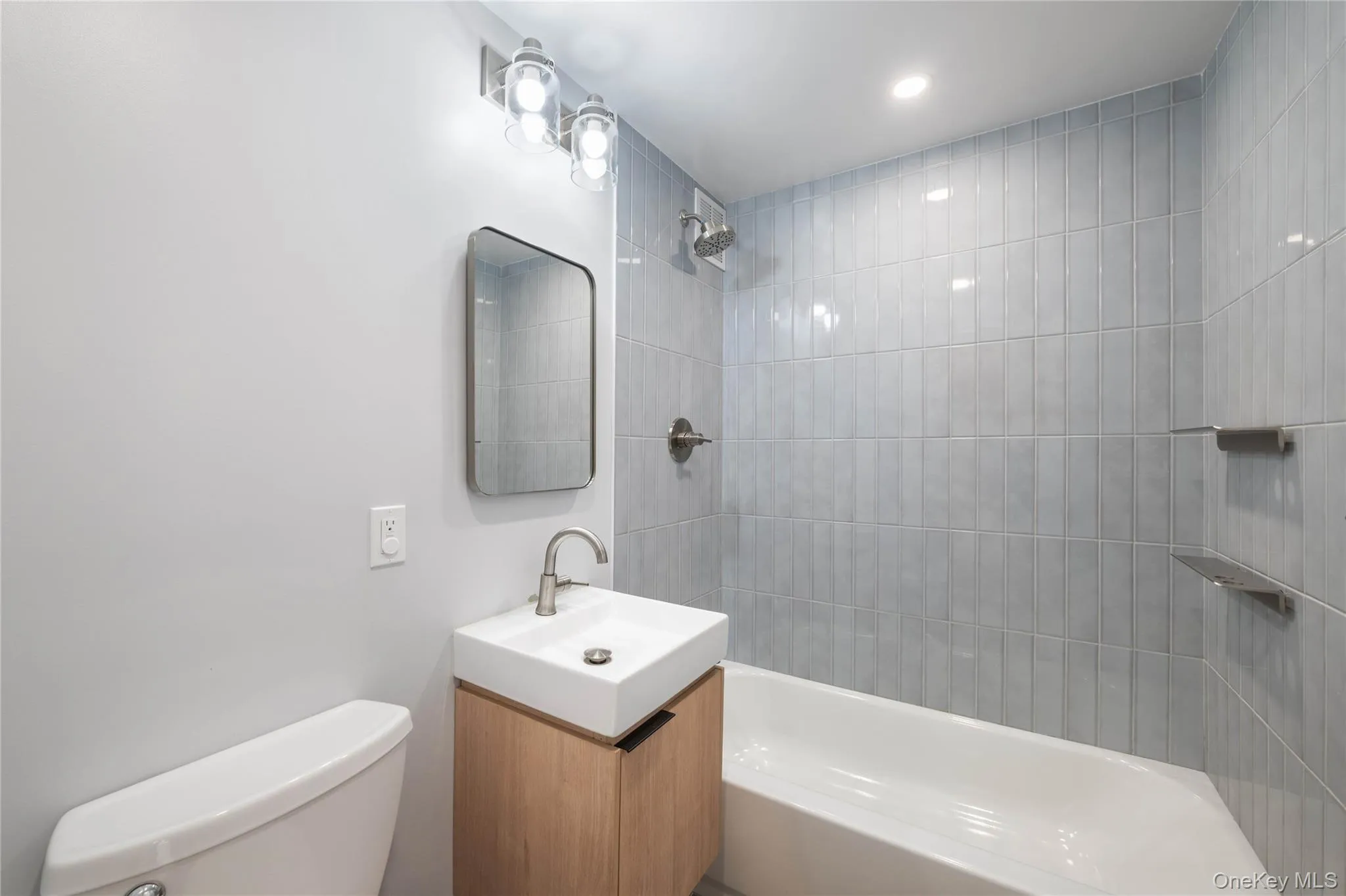 Contemporary bathroom featuring a light wood vanity with a white sink, faucet Contemporary bathroom featuring a light wood vanity with a white sink, faucet