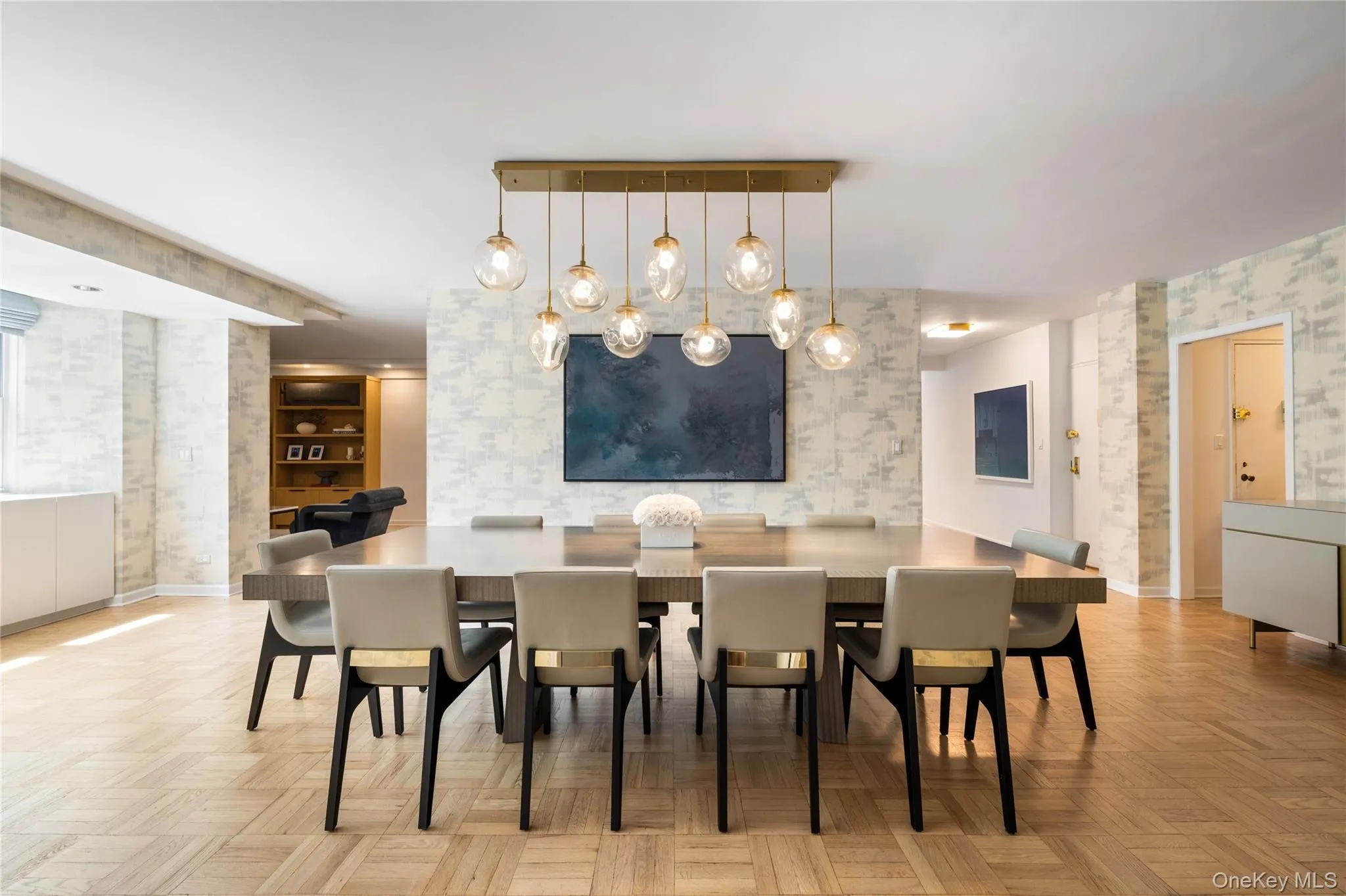 Dining space featuring parquet flooring, patterned wallpaper, and built-in window storage Dining space featuring parquet flooring, patterned wallpaper, and built-in window storage
