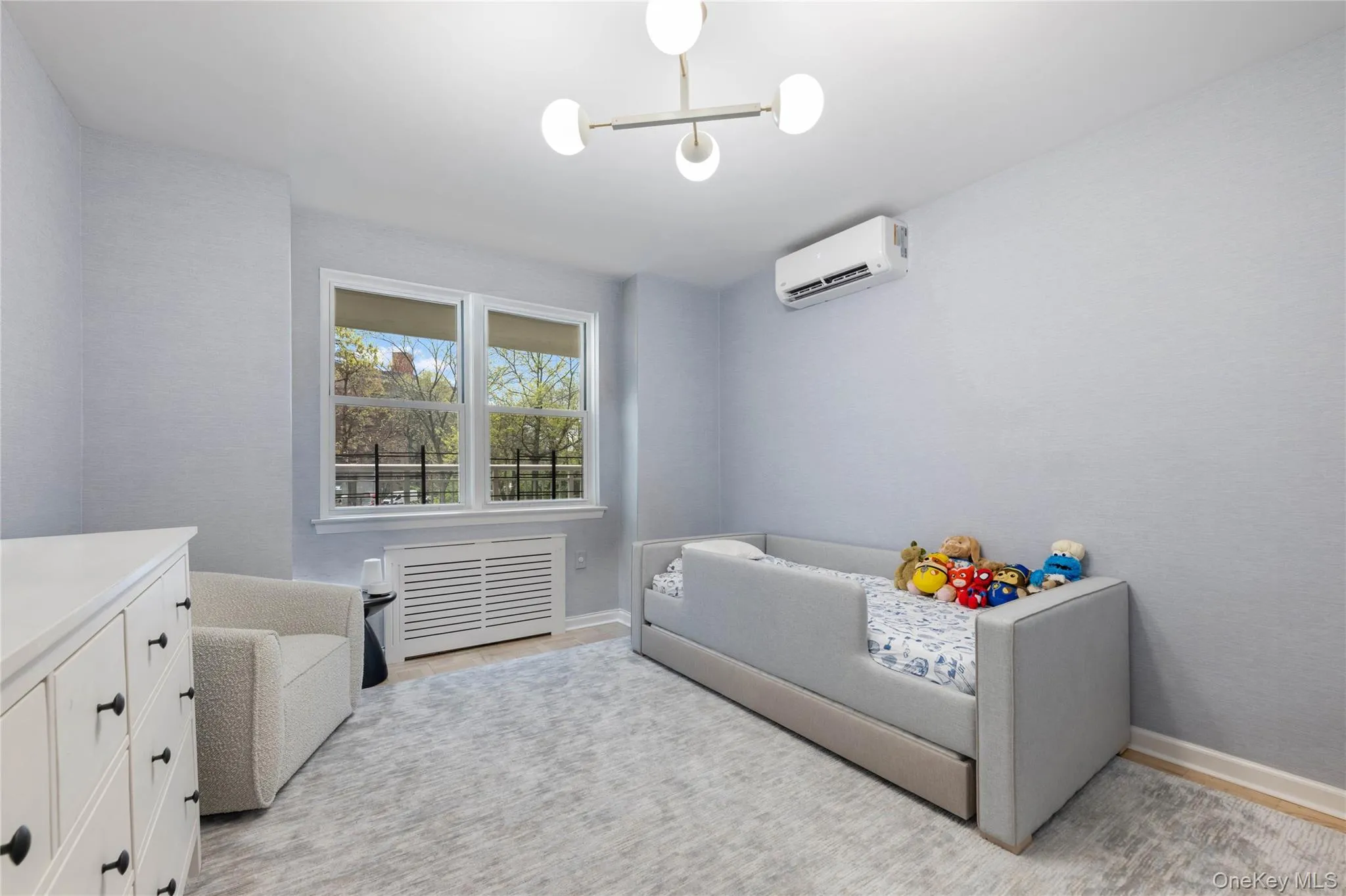 Bedoom featuring dual windows, a ceiling-mounted light fixture, a split system, and baseboard trim Bedoom featuring dual windows, a ceiling-mounted light fixture, a split system, and baseboard trim