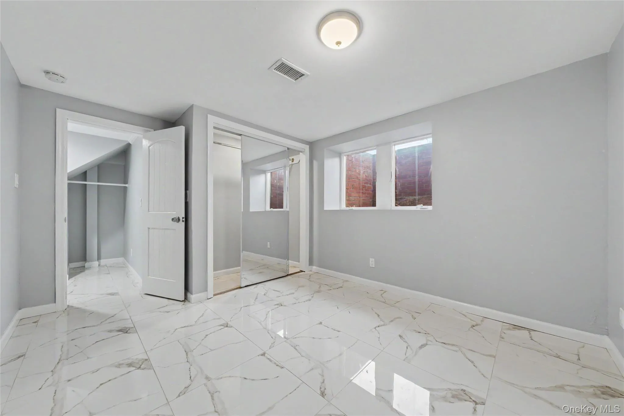 Office with light marble finish flooring and a walk in closet Office with light marble finish flooring and a walk in closet