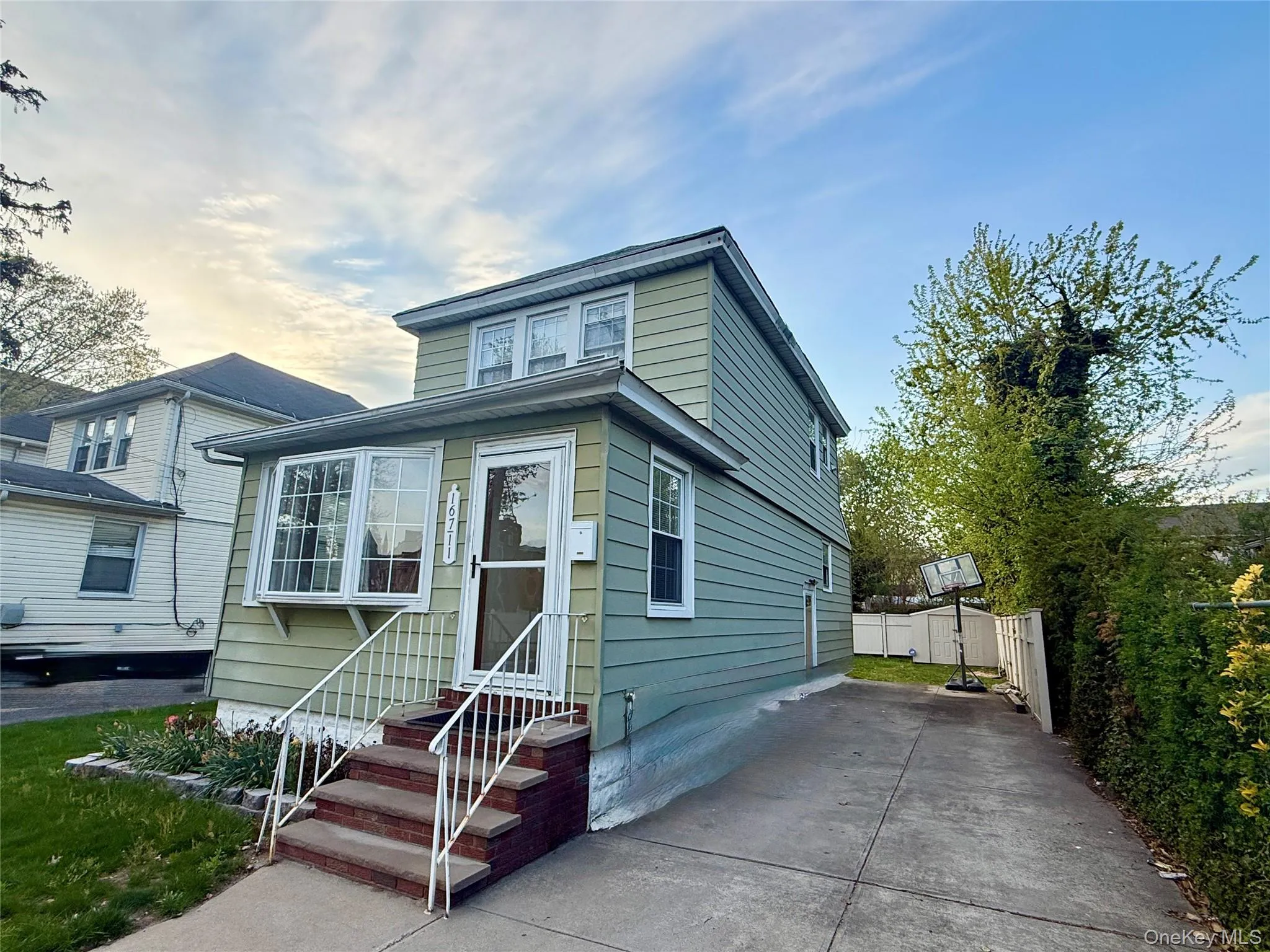 Two-story residence featuring light green siding and a bay window Two-story residence featuring light green siding and a bay window