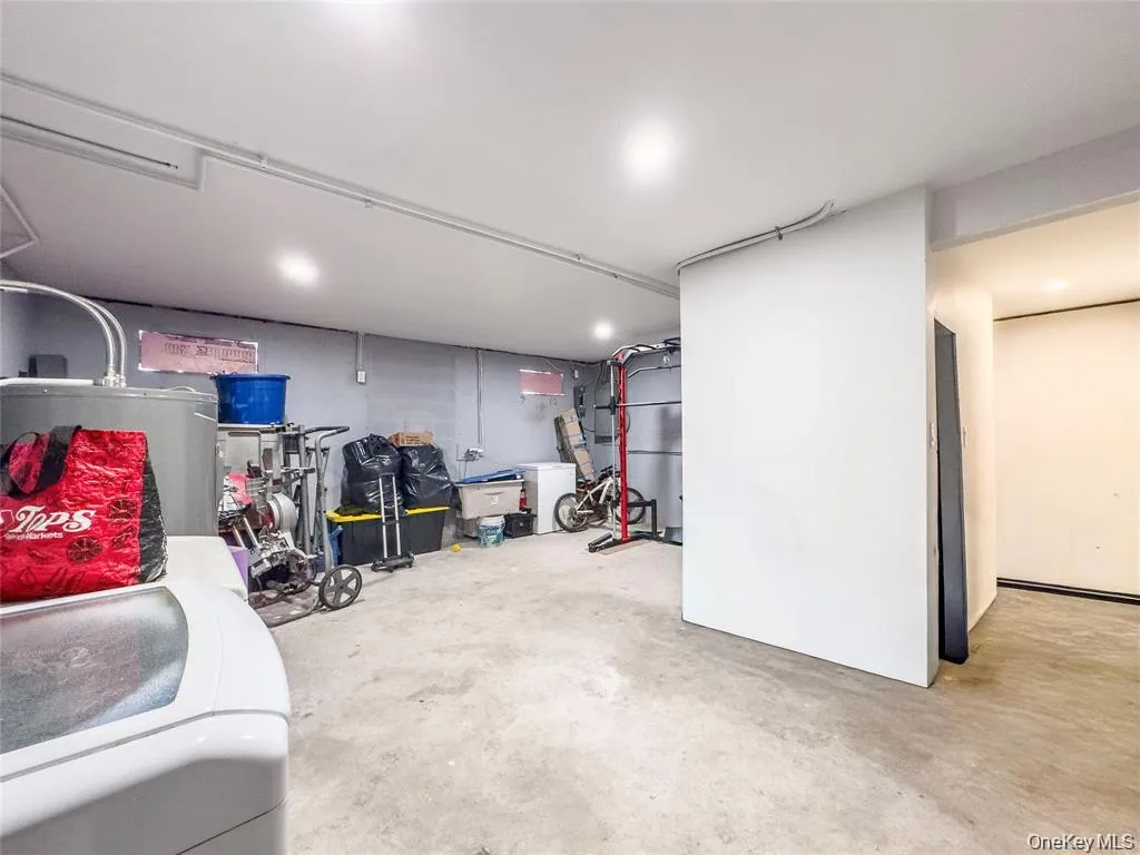 Spacious utility room featuring a concrete floor, recessed lighting, and exposed piping Spacious utility room featuring a concrete floor, recessed lighting, and exposed piping