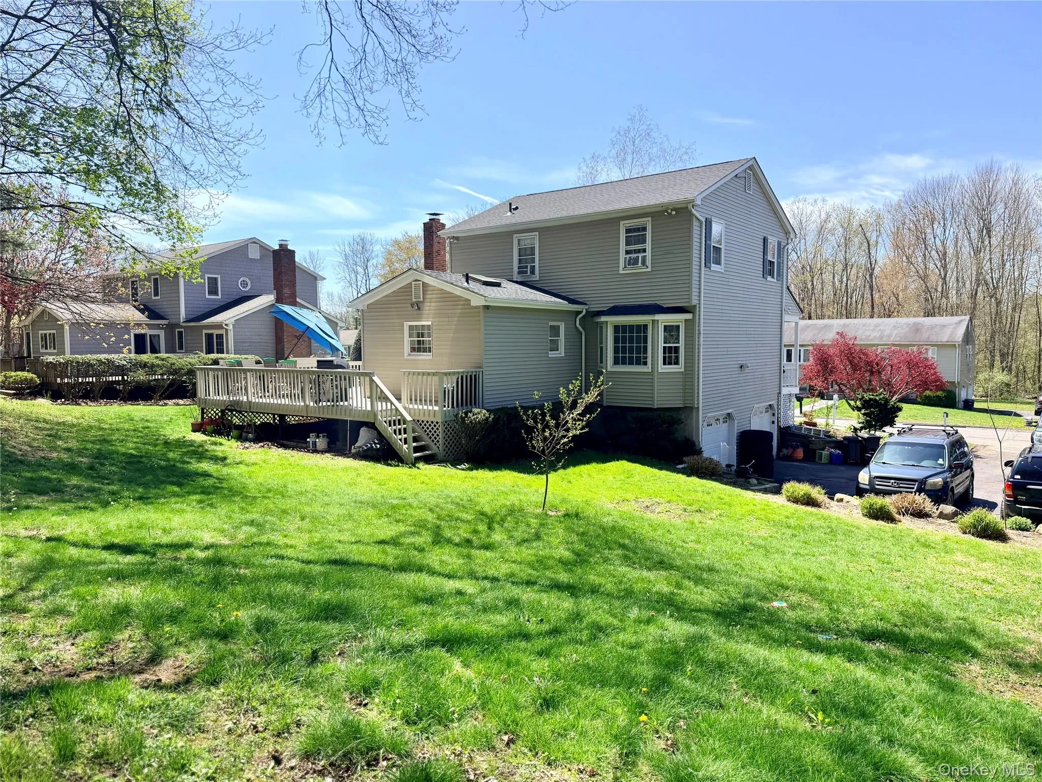 Spacious backyard featuring a multi-level deck with stairs, a manicured lawn, and mature trees Spacious backyard featuring a multi-level deck with stairs, a manicured lawn, and mature trees