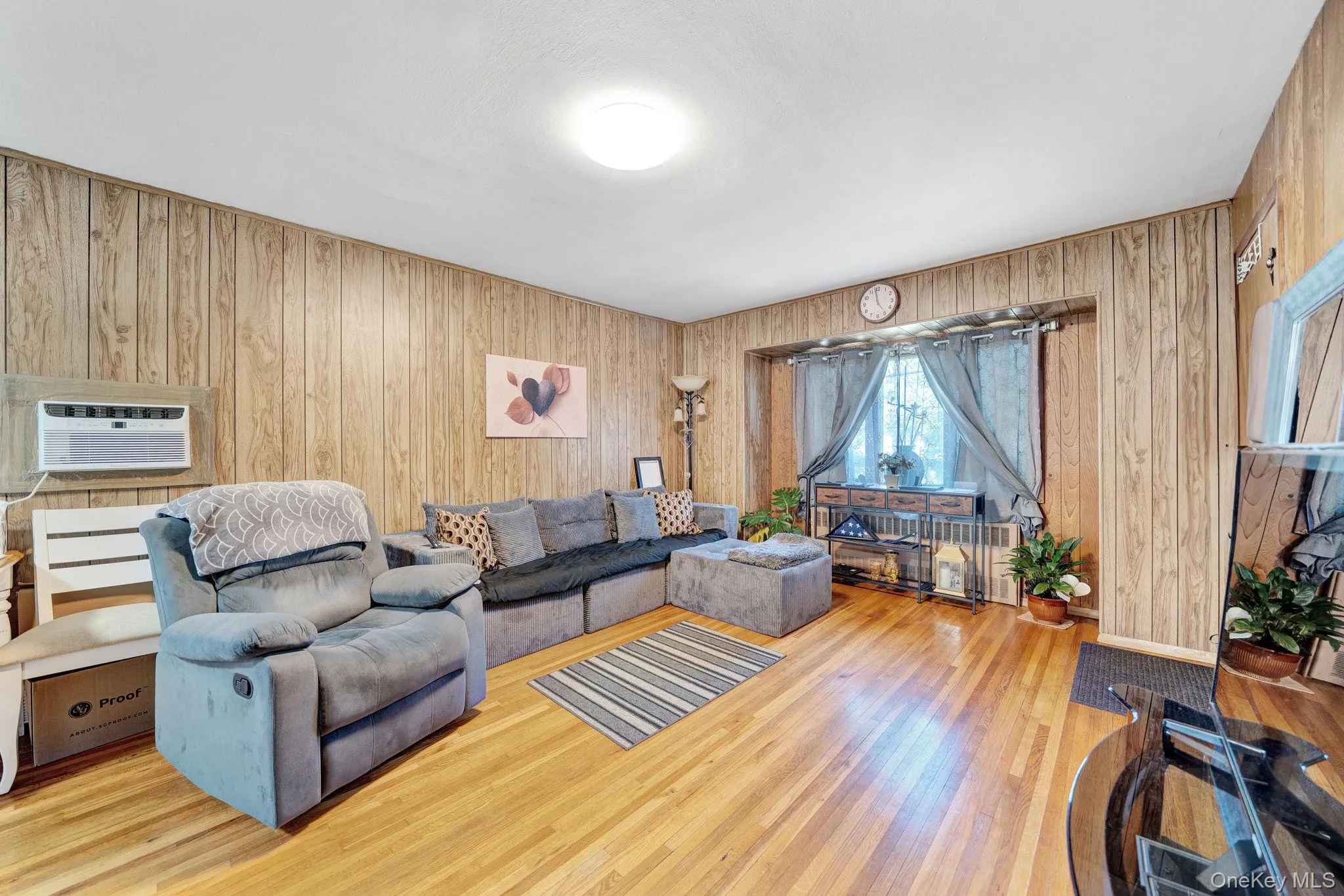 Living area featuring wood-finish wall paneling and a recessed window Living area featuring wood-finish wall paneling and a recessed window