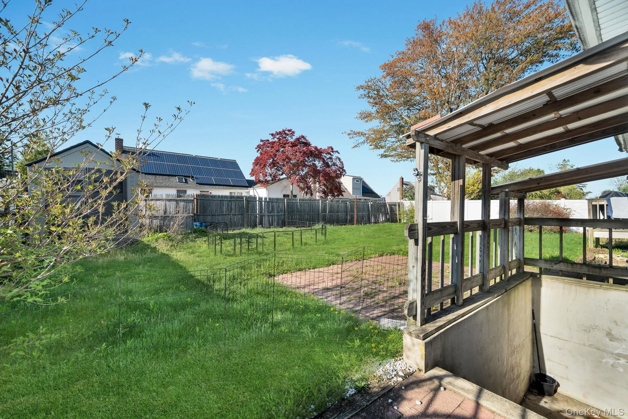 Expansive green lawn with a wooden perimeter fence basement private entrance Expansive green lawn with a wooden perimeter fence basement private entrance