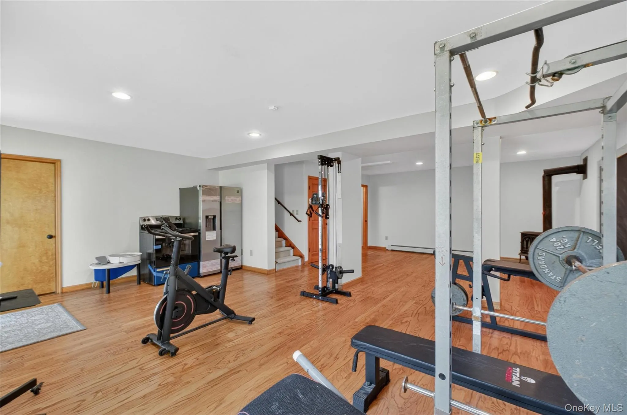 Spacious basement featuring wood-finish flooring, recessed lighting, and bright white walls. Spacious basement featuring wood-finish flooring, recessed lighting, and bright white walls.
