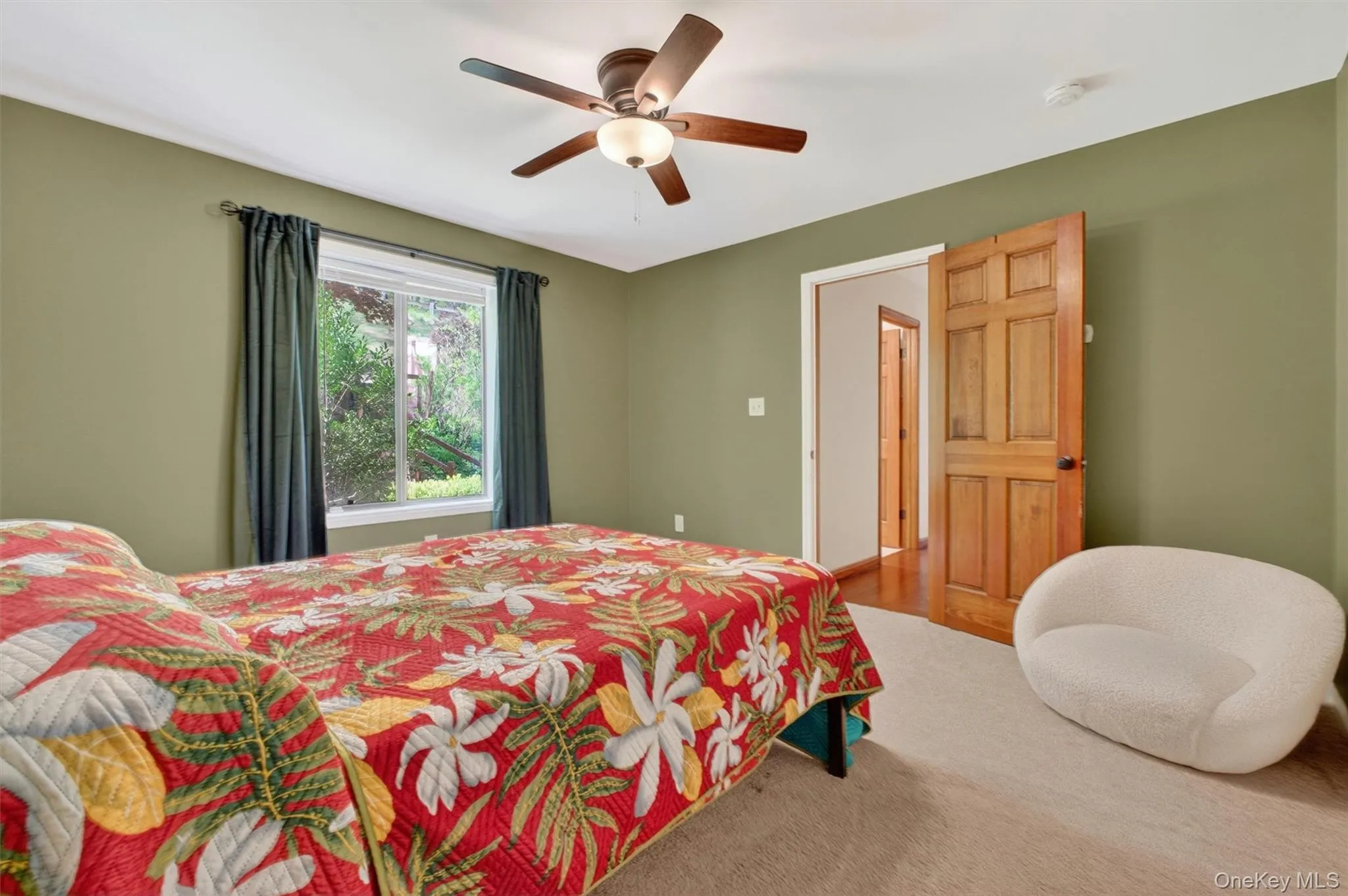 Large bedroom featuring neutral-toned carpeting, olive green walls, and white trim. Large bedroom featuring neutral-toned carpeting, olive green walls, and white trim.