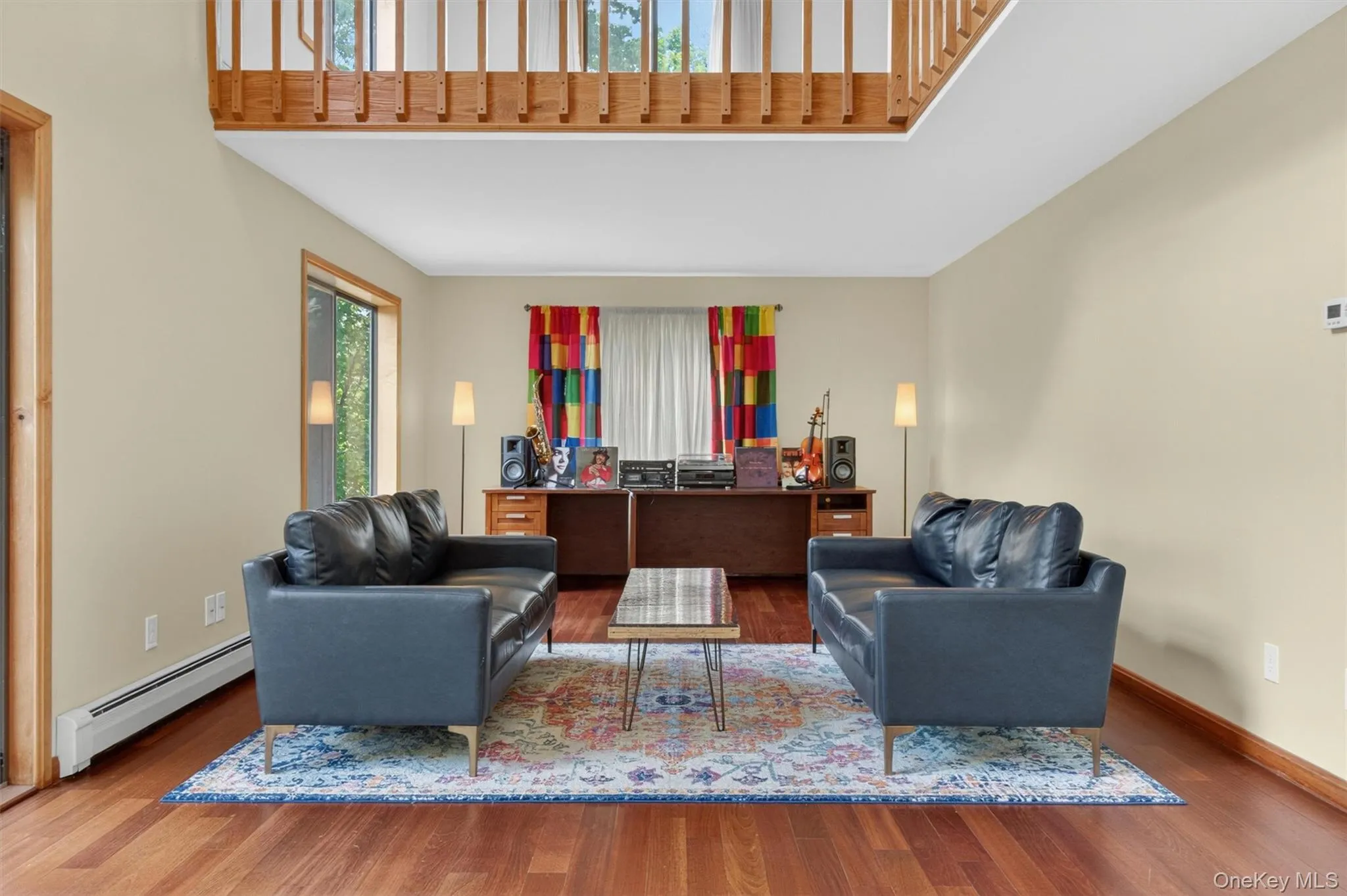 Spacious and bright interior featuring high ceilings, wood-finish flooring, and a sliding glass door providing outdoor access to a deck. Spacious and bright interior featuring high ceilings, wood-finish flooring, and a sliding glass door providing outdoor access to a deck.