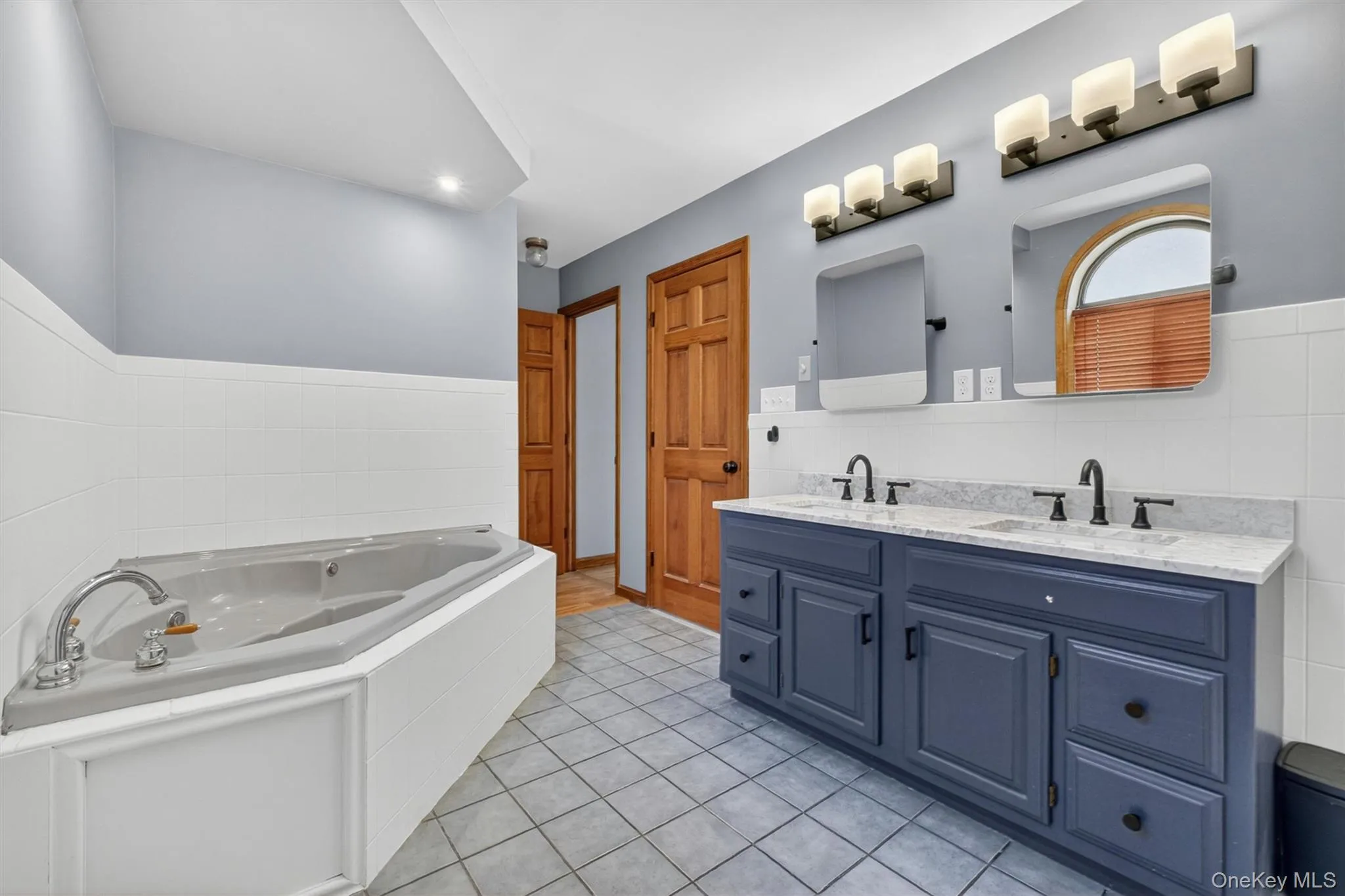 Bathroom featuring a jetted jacuzzi, dual vanity with undermount sinks and dark bronze fixtures, and a shower. Bathroom featuring a jetted jacuzzi, dual vanity with undermount sinks and dark bronze fixtures, and a shower.