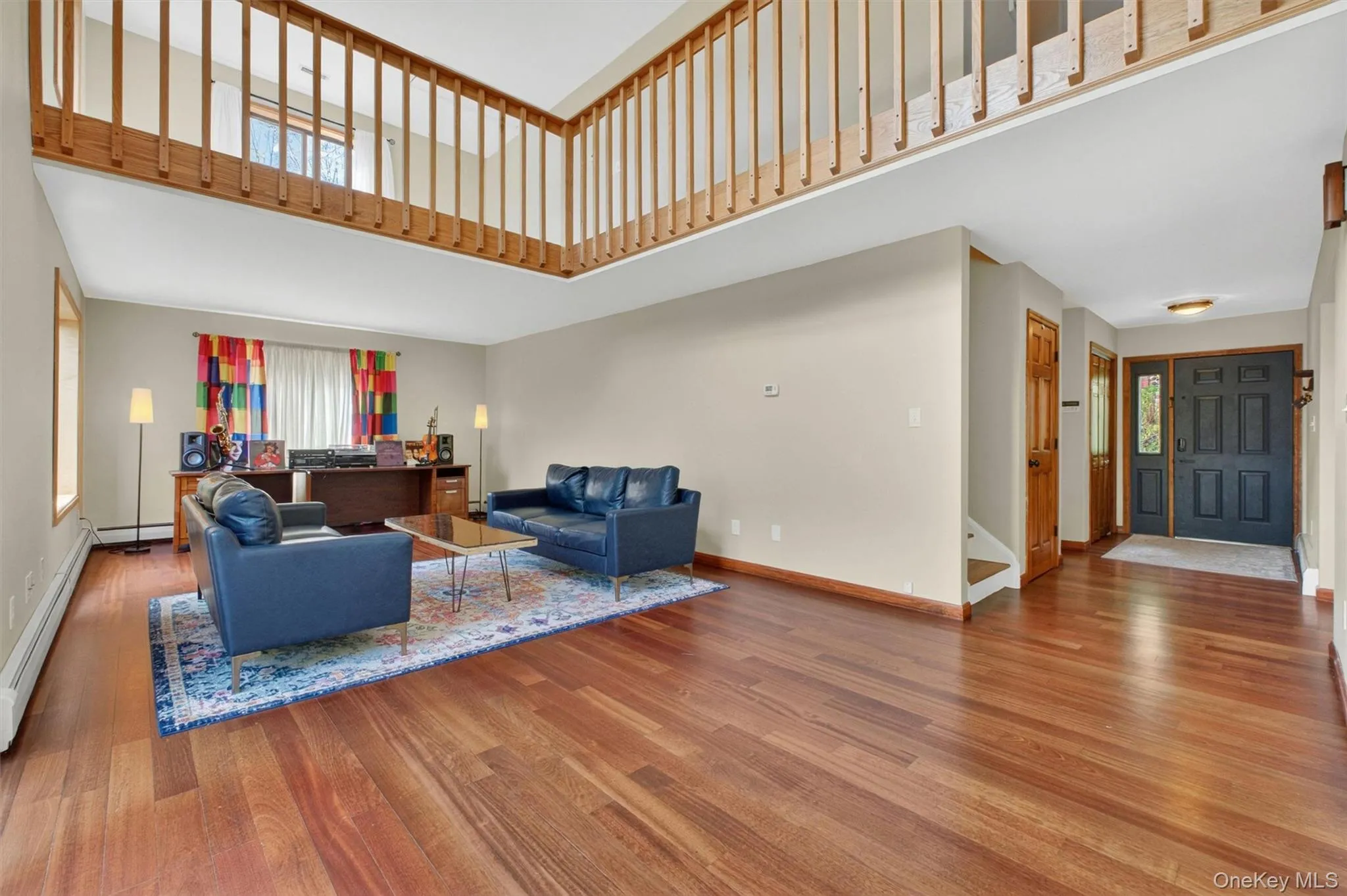 Spacious and bright interior featuring high ceilings, wood-finish flooring, and a sliding glass door providing outdoor access to a deck. Spacious and bright interior featuring high ceilings, wood-finish flooring, and a sliding glass door providing outdoor access to a deck.