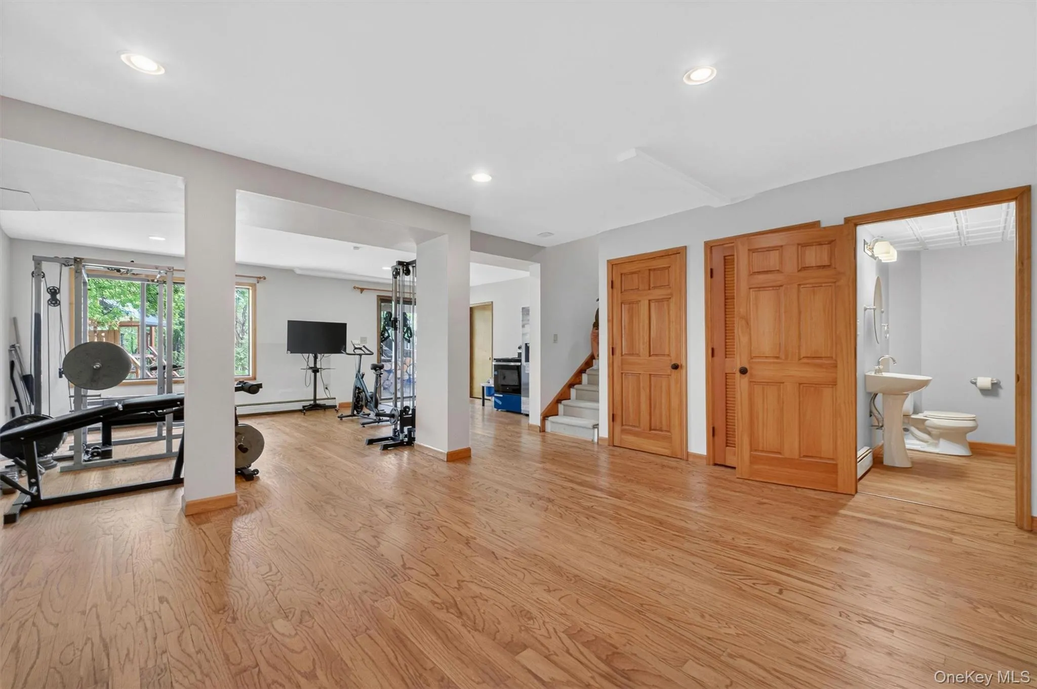 Spacious basement featuring wood-finish flooring, recessed lighting, and bright white walls. Spacious basement featuring wood-finish flooring, recessed lighting, and bright white walls.