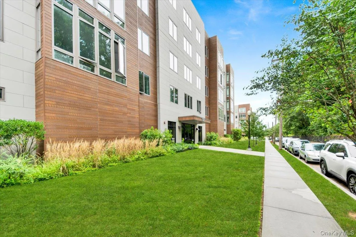 Contemporary multi-story building featuring a facade of light-toned siding and horizontal wood-finish panels Contemporary multi-story building featuring a facade of light-toned siding and horizontal wood-finish panels