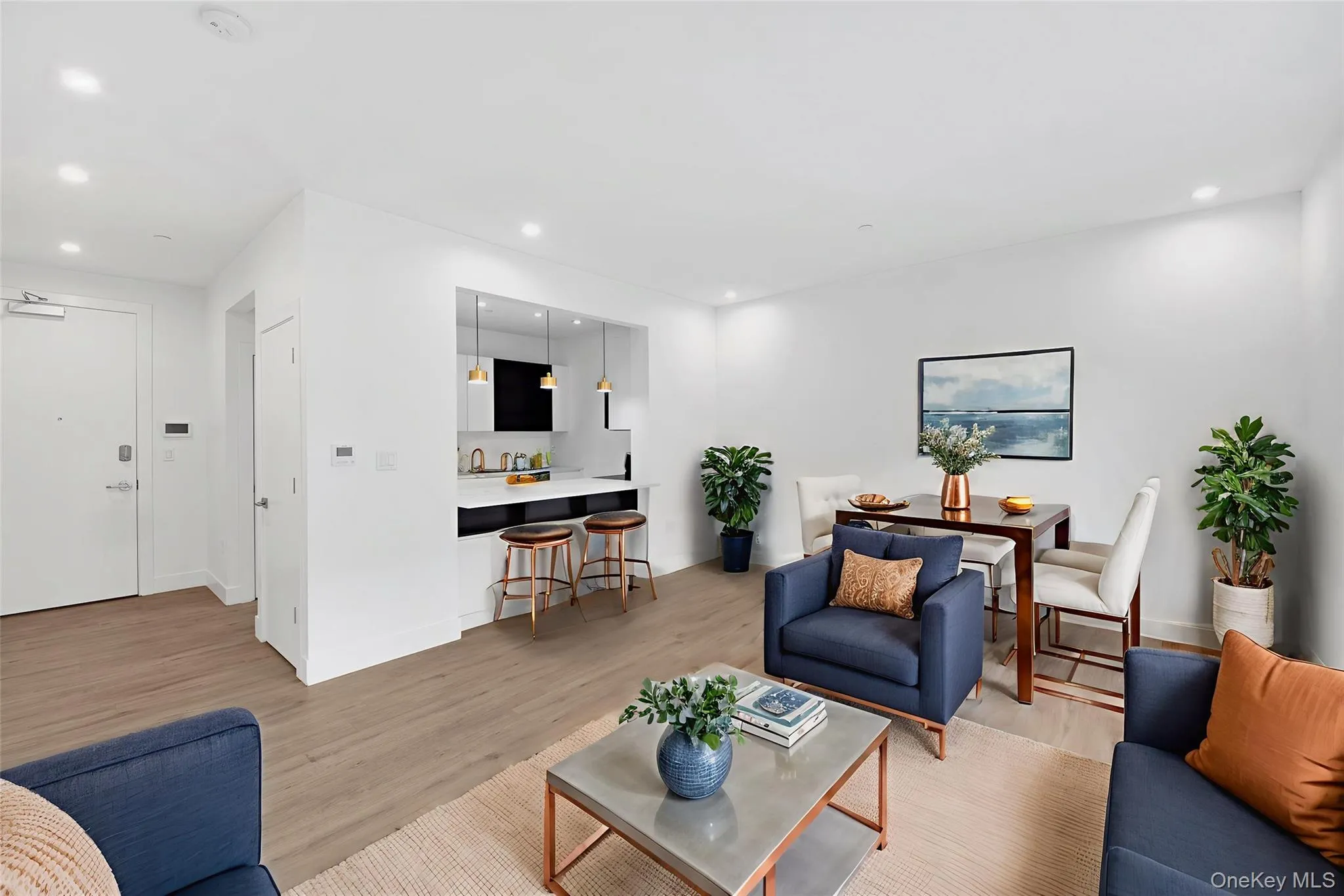 Open-concept living area featuring wood-finish flooring, recessed lighting, and a defined dining space Open-concept living area featuring wood-finish flooring, recessed lighting, and a defined dining space
