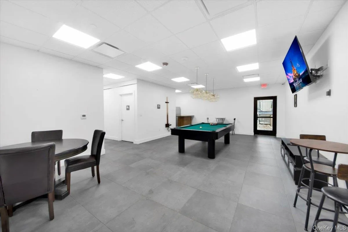 Spacious common area featuring large format grey tile flooring, recessed lighting, and a drop ceiling Spacious common area featuring large format grey tile flooring, recessed lighting, and a drop ceiling