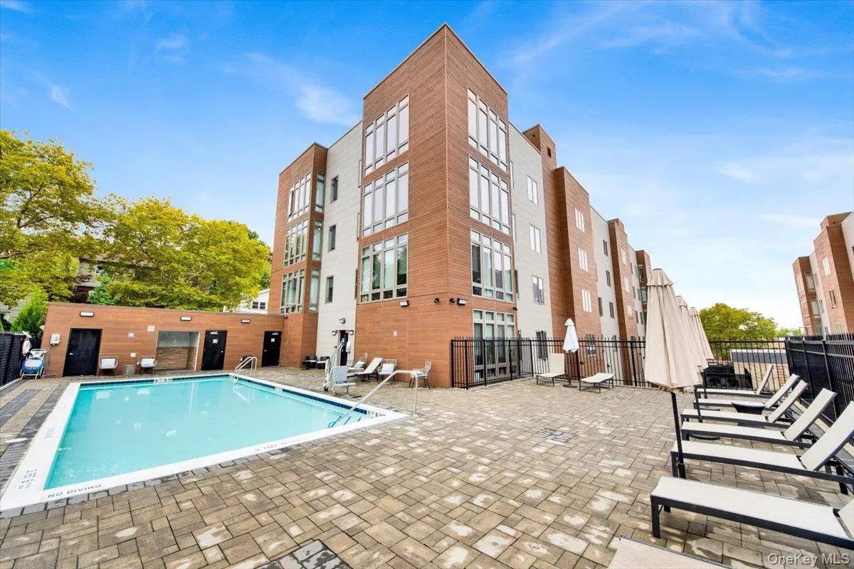 Outdoor swimming pool with a surrounding paver patio and lounge areas Outdoor swimming pool with a surrounding paver patio and lounge areas