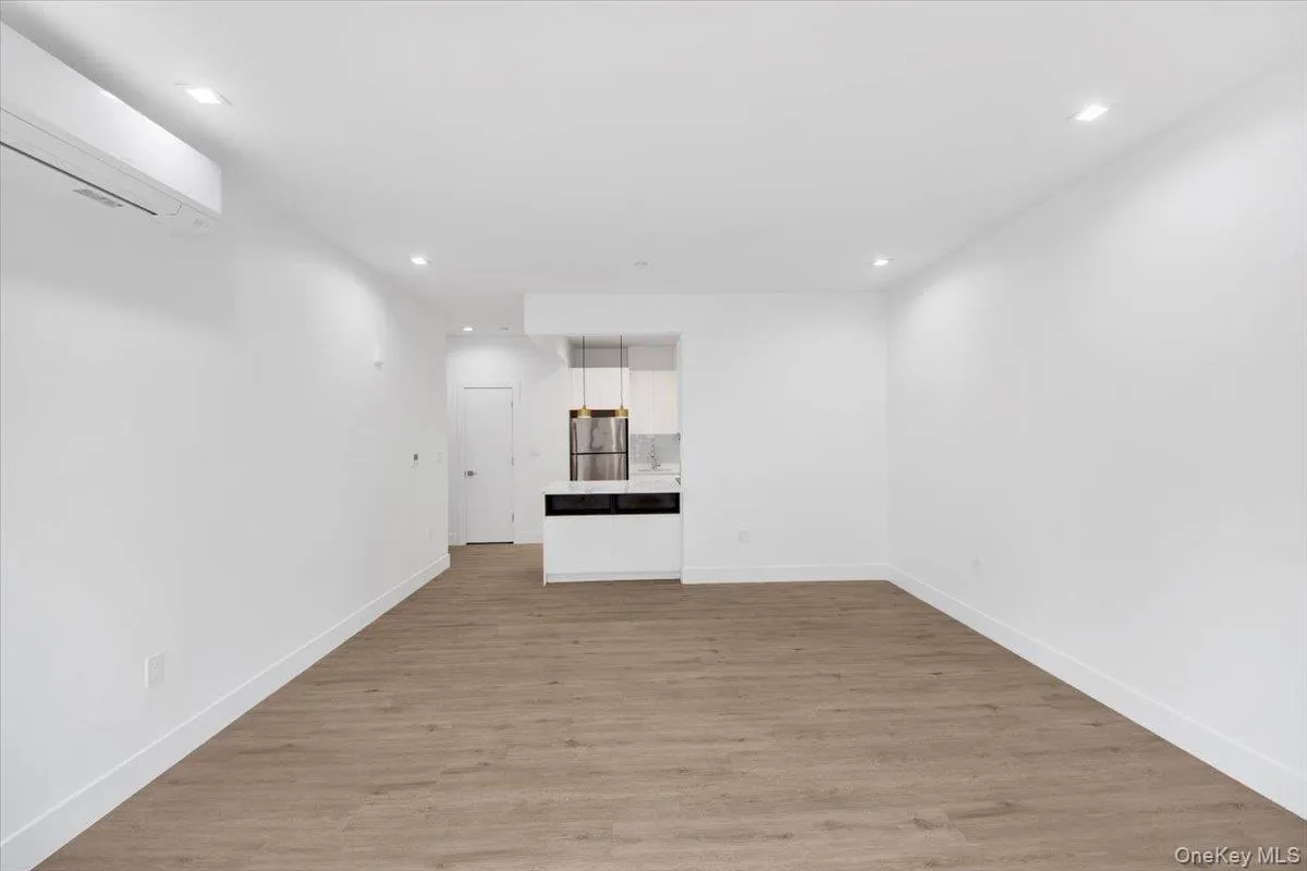 Open-concept living area featuring wood-finish flooring, recessed lighting, and a ductless mini-split system Open-concept living area featuring wood-finish flooring, recessed lighting, and a ductless mini-split system