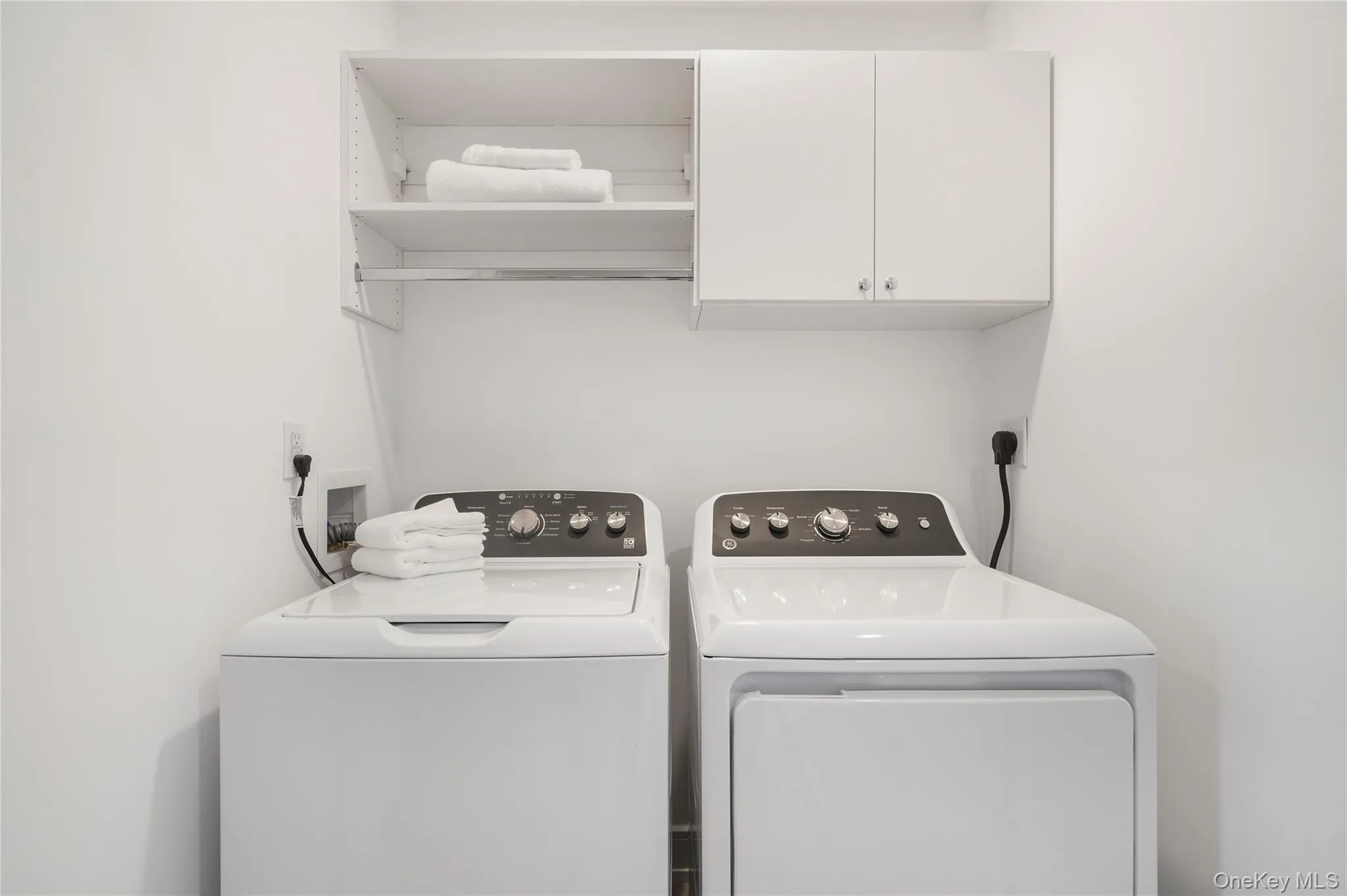 Laundry room featuring cabinets and washing machine and clothes dryer Laundry room featuring cabinets and washing machine and clothes dryer