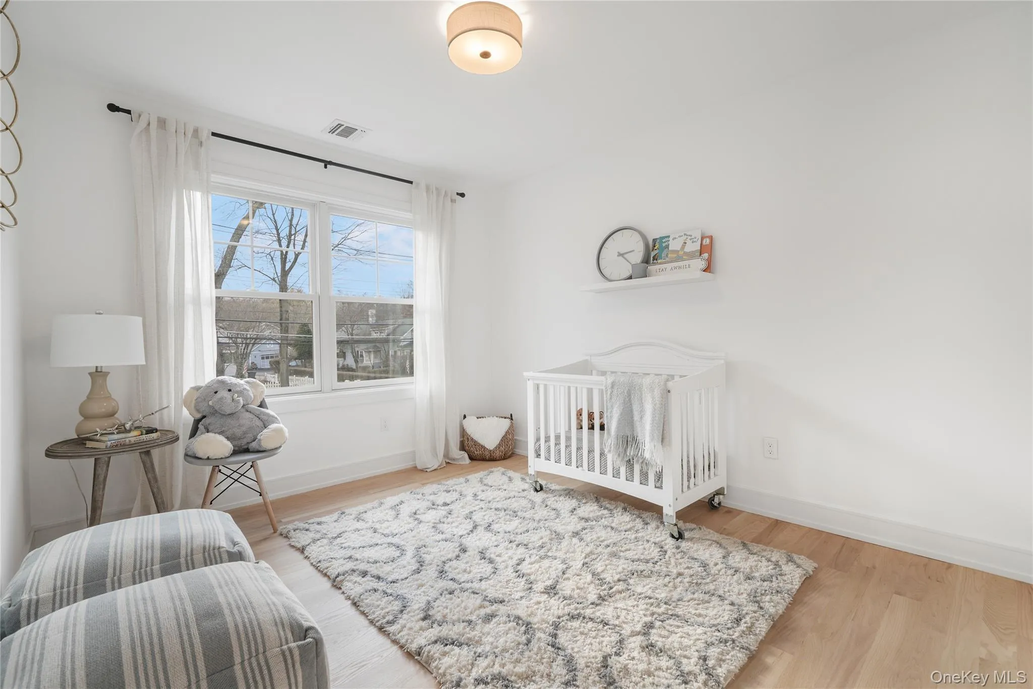 Bedroom featuring a nursery area and light hardwood / wood-style floors Bedroom featuring a nursery area and light hardwood / wood-style floors