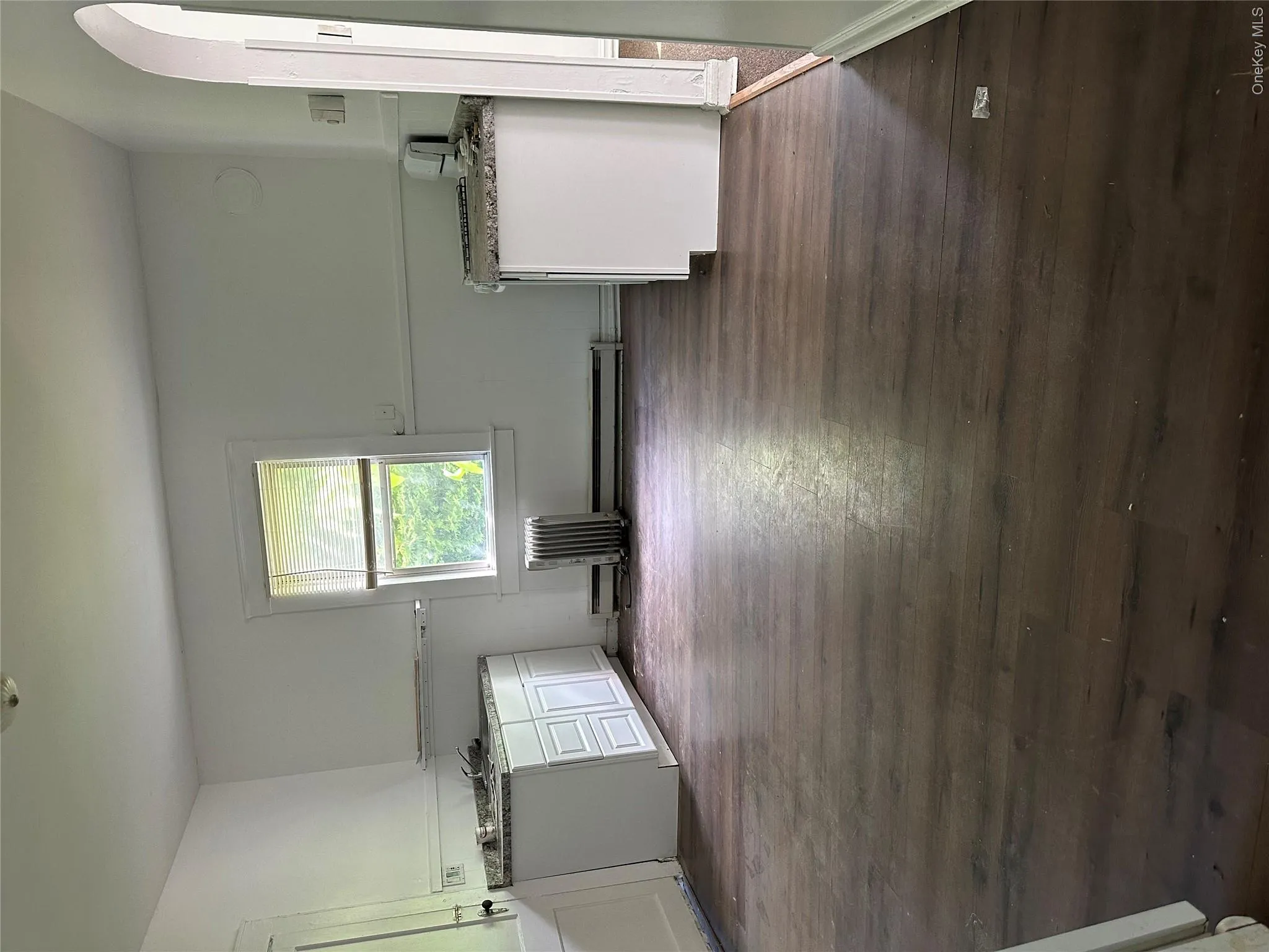Kitchen with dark hardwood / wood-style flooring and white cabinetry Kitchen with dark hardwood / wood-style flooring and white cabinetry