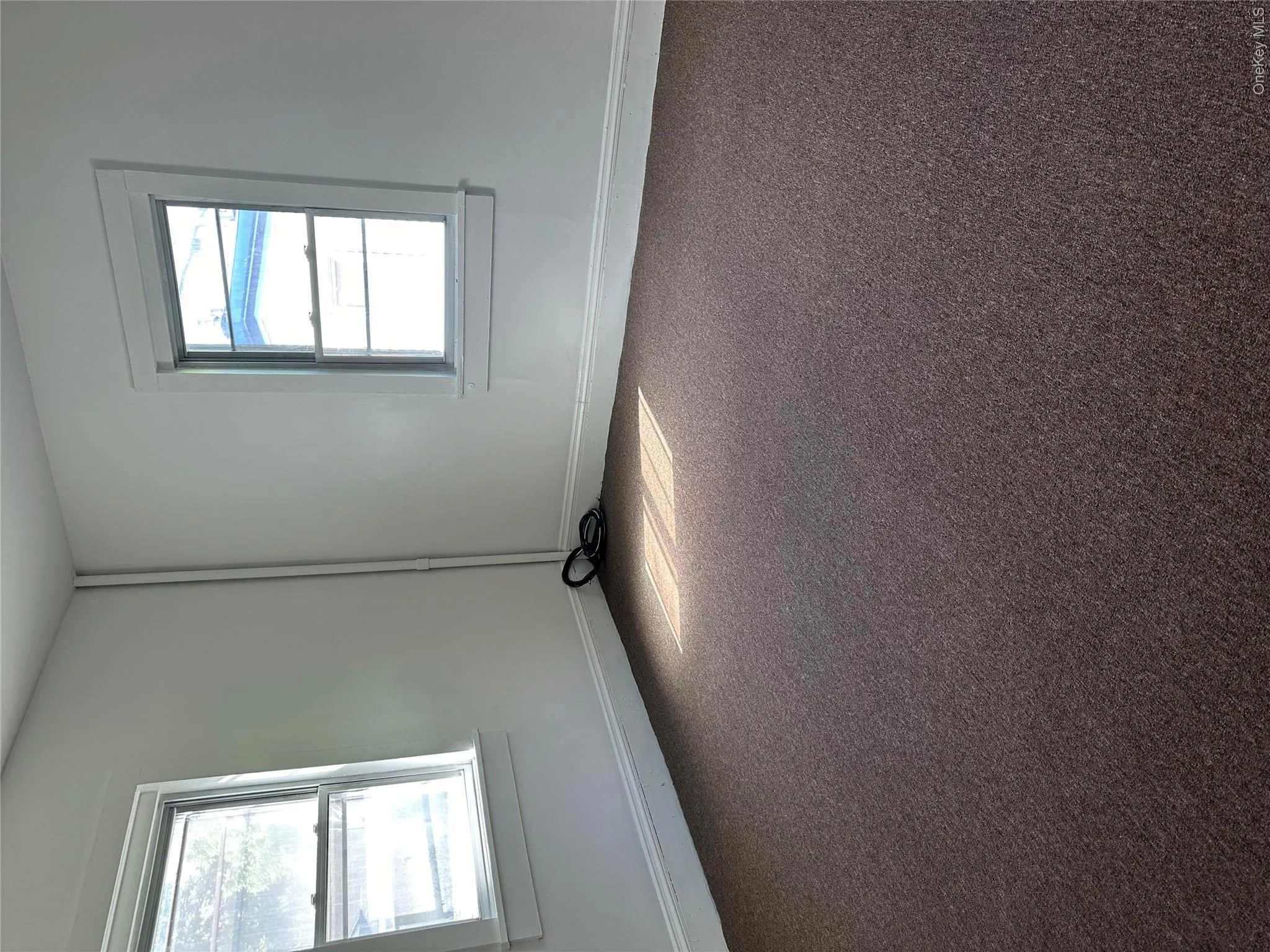 Unfurnished room with plenty of natural light and carpet floors Unfurnished room with plenty of natural light and carpet floors