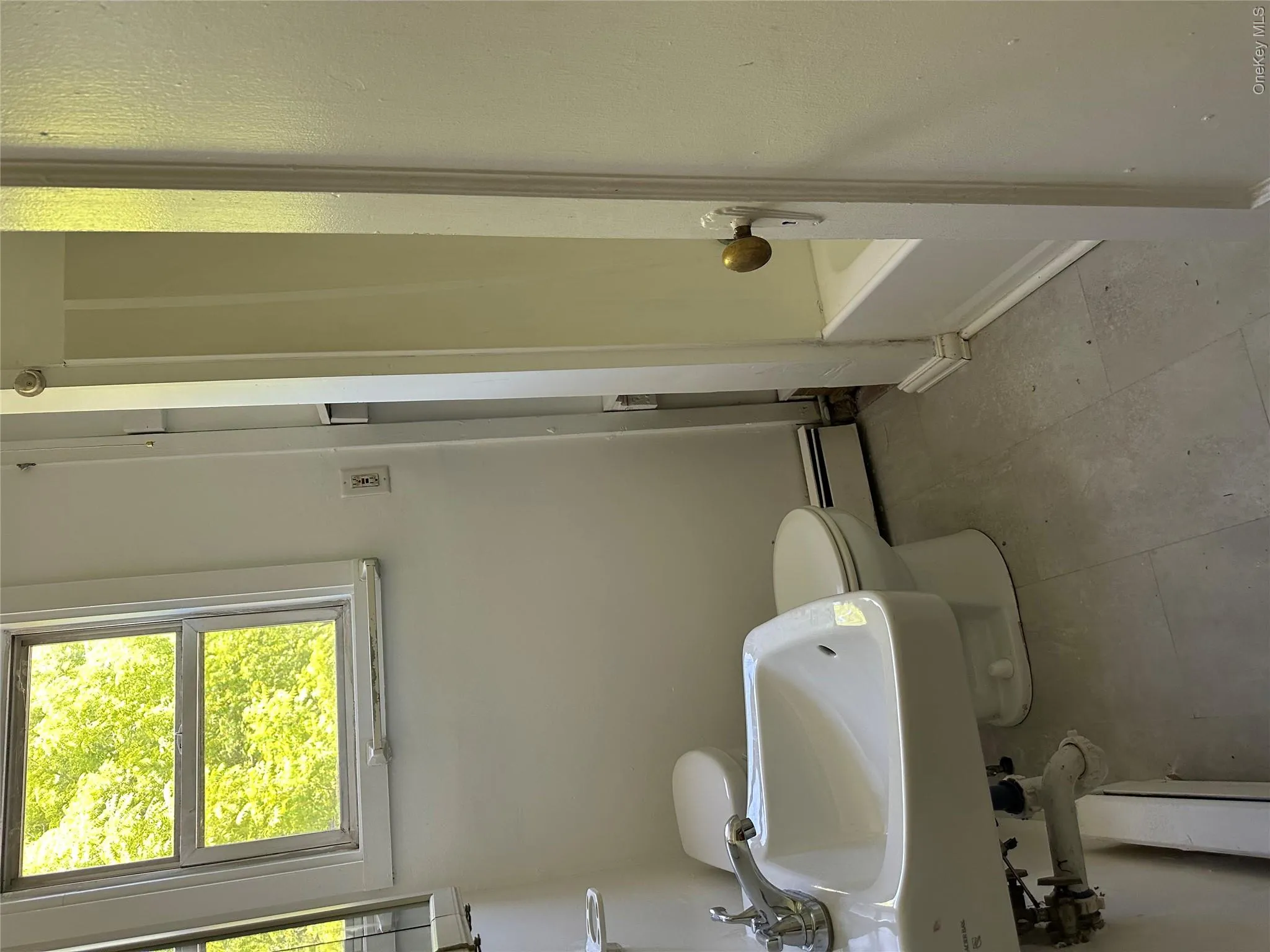 Bathroom with toilet, a baseboard heating unit, and sink Bathroom with toilet, a baseboard heating unit, and sink