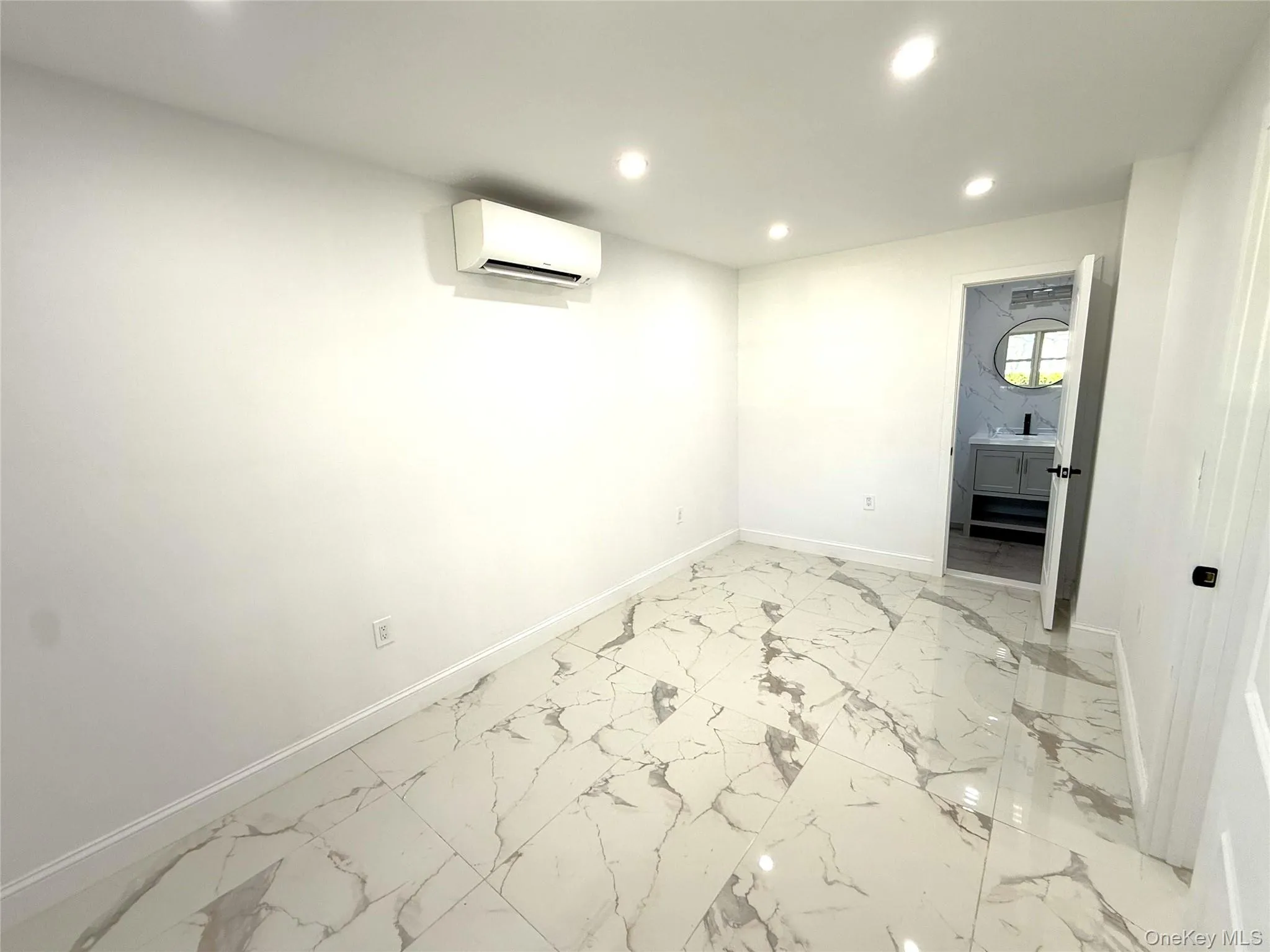 White walls complement large format porcelain tile flooring with grey veining White walls complement large format porcelain tile flooring with grey veining
