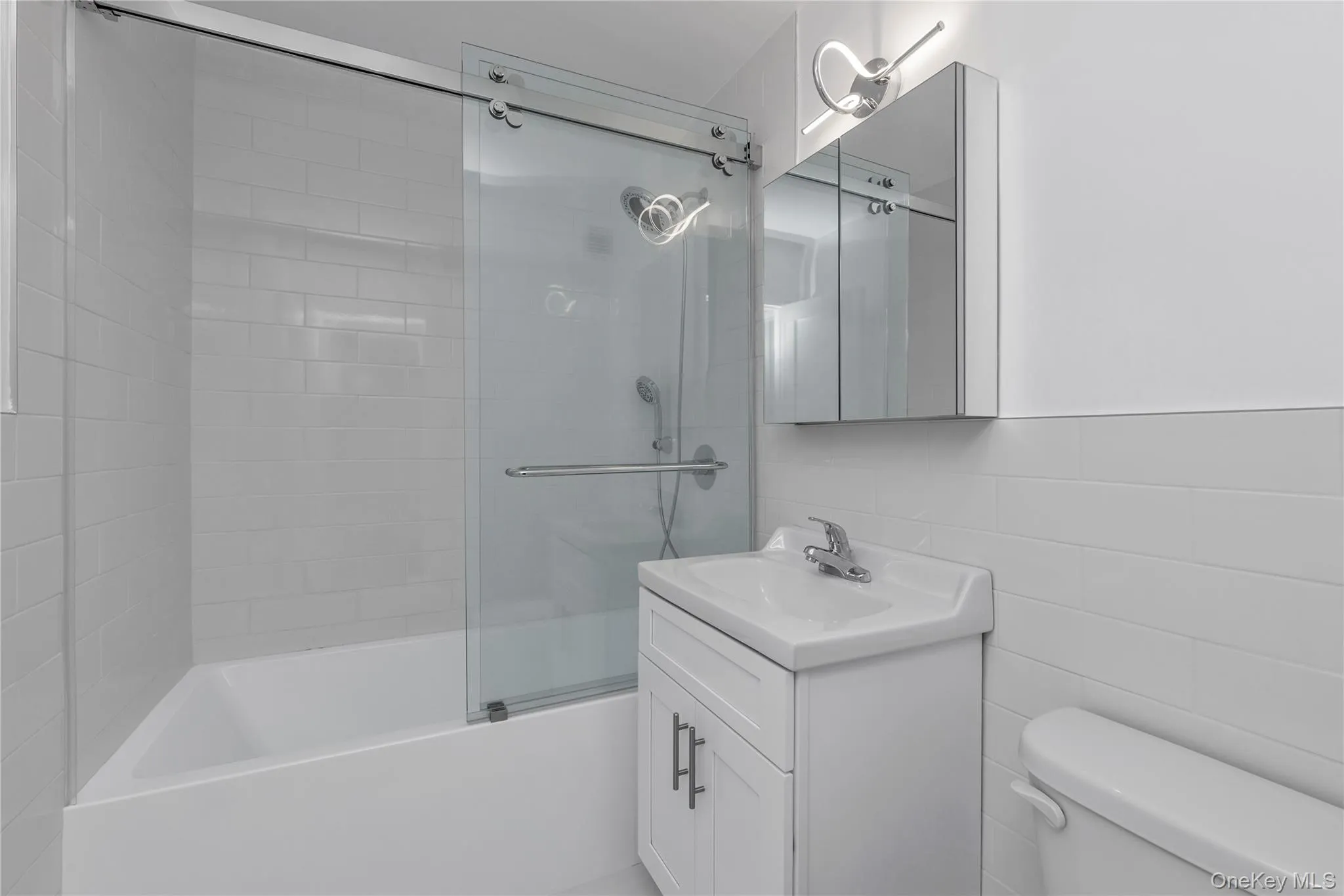NEW hallway bath with sliding doors, new tub, cabinet toilet and lighting NEW hallway bath with sliding doors, new tub, cabinet toilet and lighting