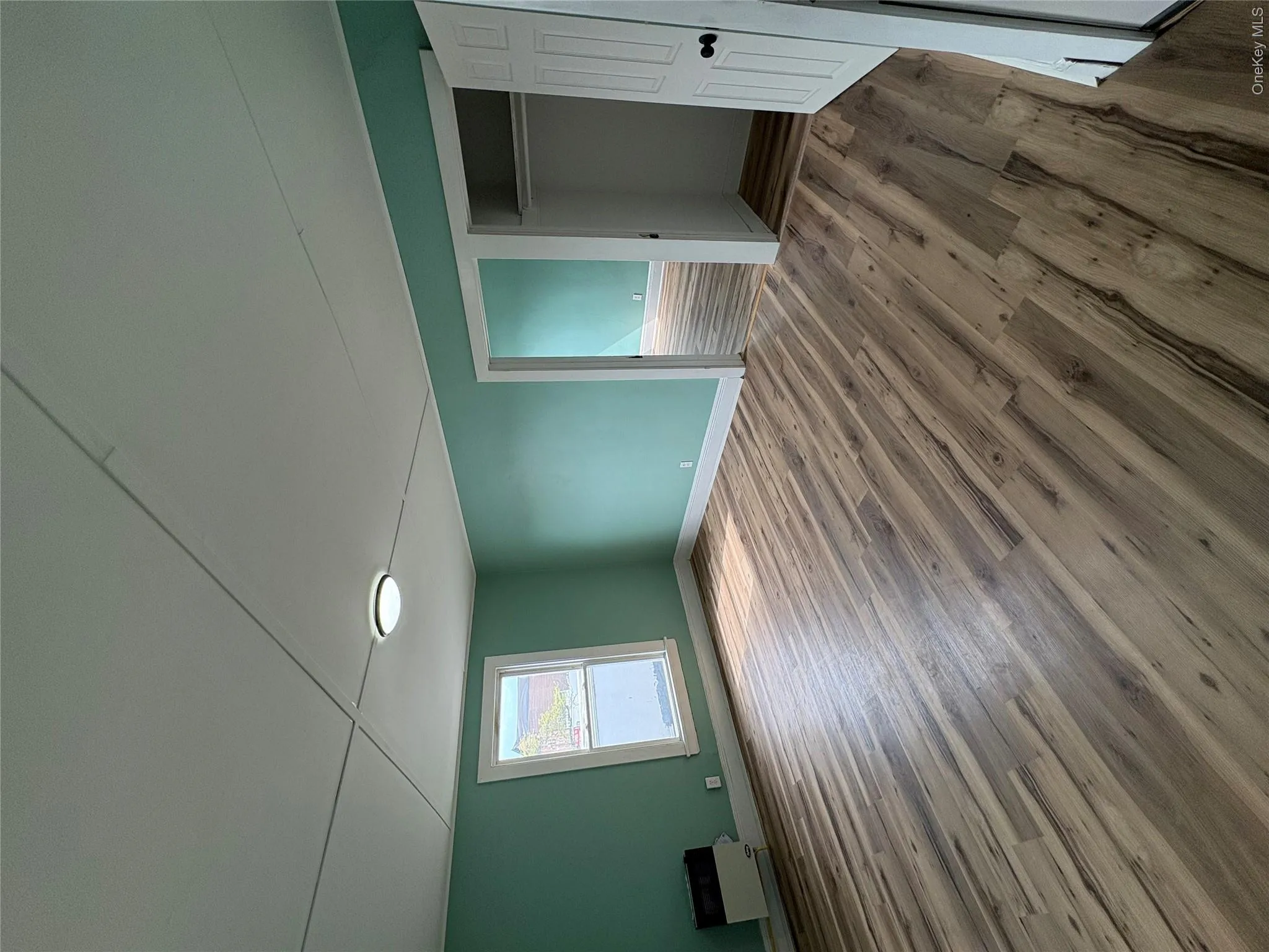 Spacious interior room featuring , a window with white trim, and a ceiling-mounted light fixture Spacious interior room featuring , a window with white trim, and a ceiling-mounted light fixture