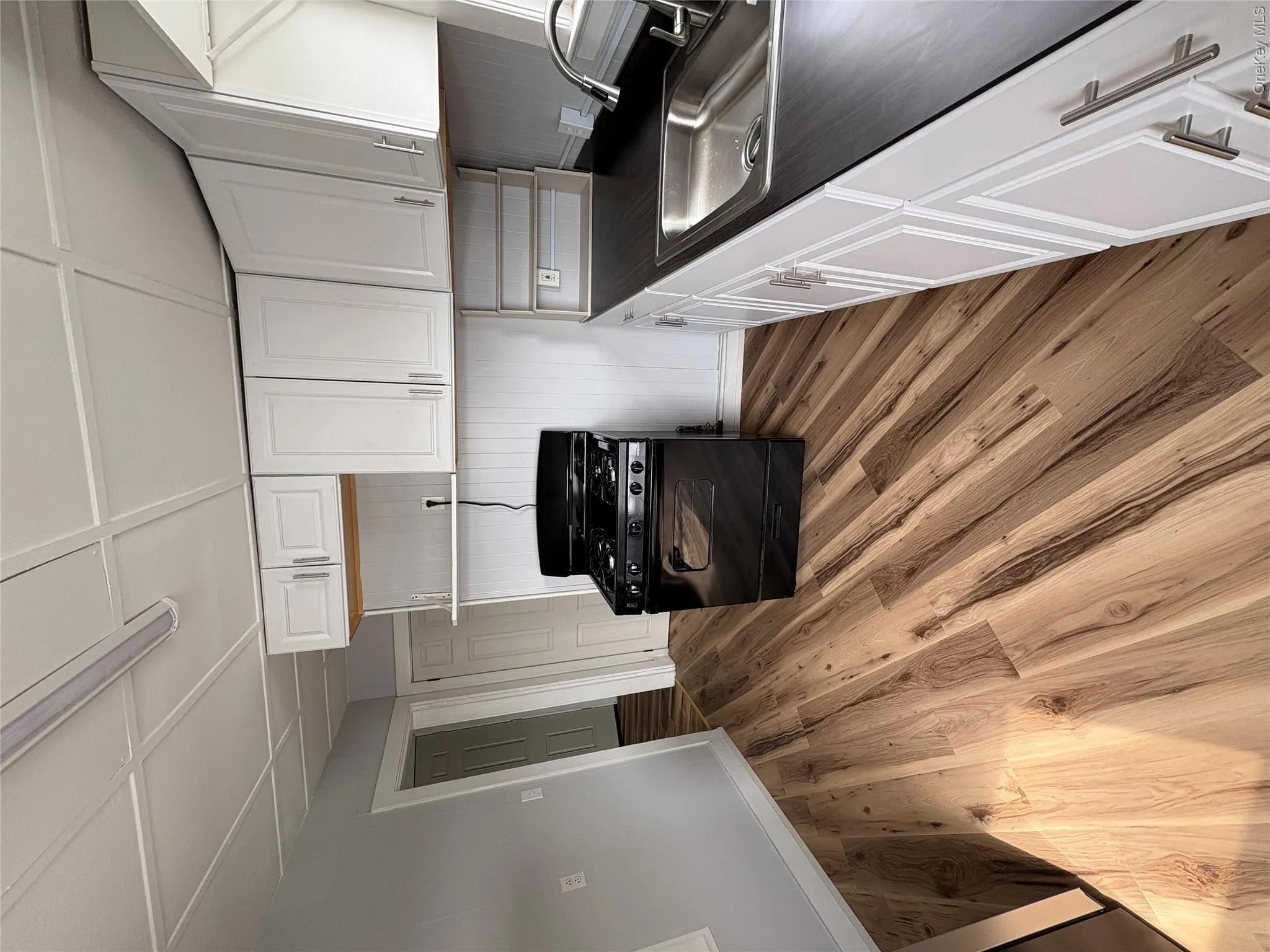 Kitchen featuring , white shaker-style cabinetry, dark countertops, a stainless steel sink, and a black gas range Kitchen featuring , white shaker-style cabinetry, dark countertops, a stainless steel sink, and a black gas range