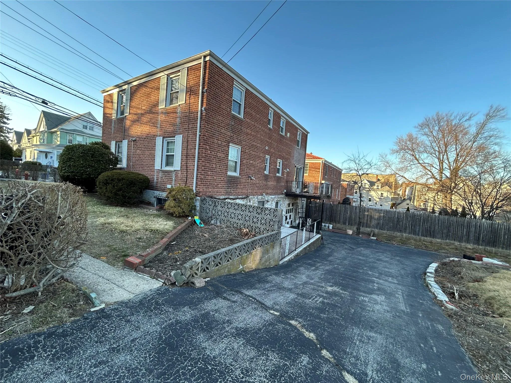 View of property exterior featuring brick siding and fence View of property exterior featuring brick siding and fence