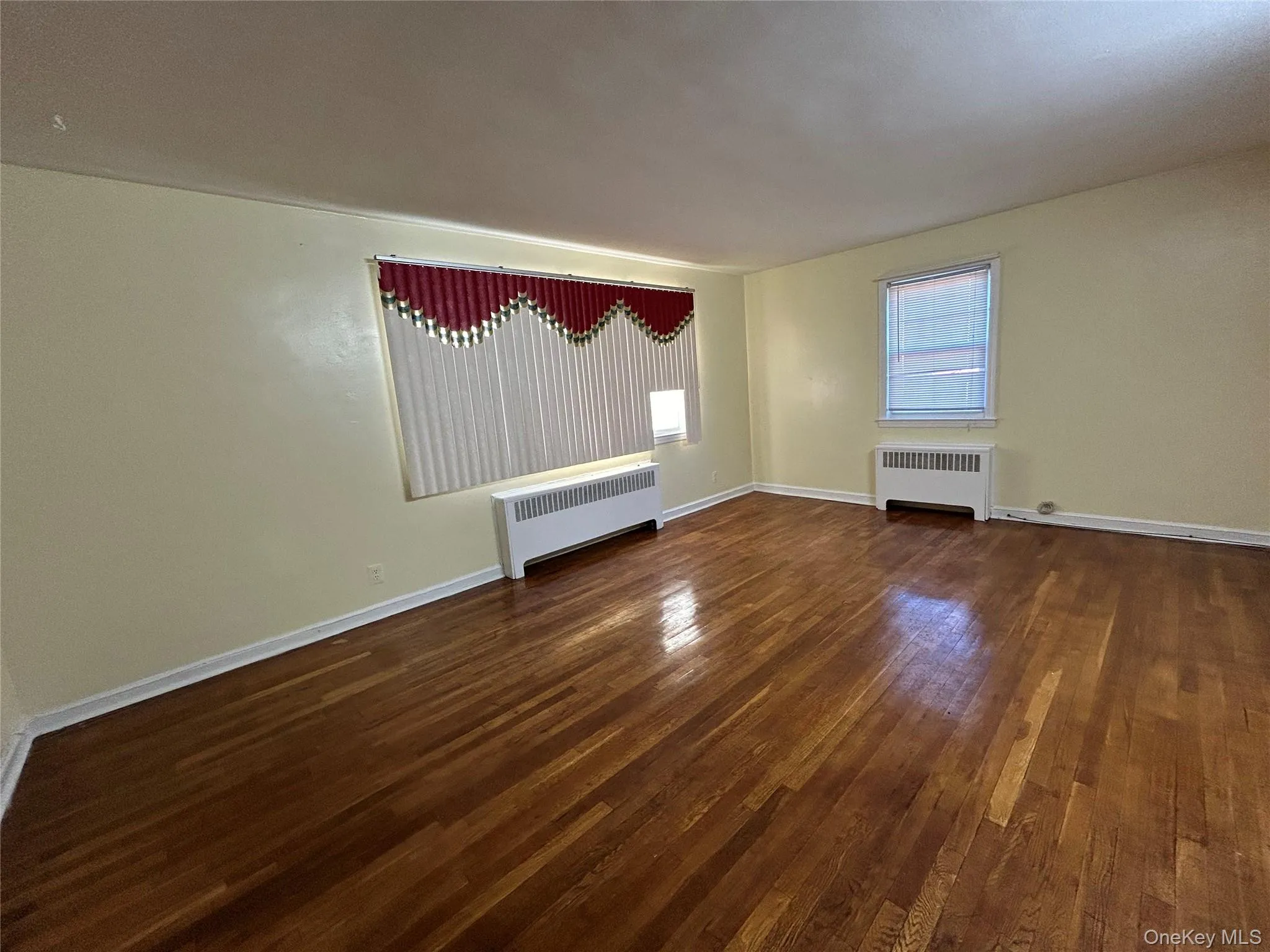 Spare room featuring baseboards, hardwood / wood-style floors, and radiator Spare room featuring baseboards, hardwood / wood-style floors, and radiator