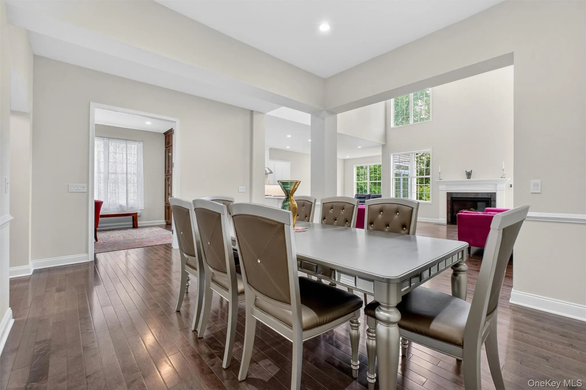 Open-concept dining area featuring grey wood-finish flooring and a chair rail Open-concept dining area featuring grey wood-finish flooring and a chair rail