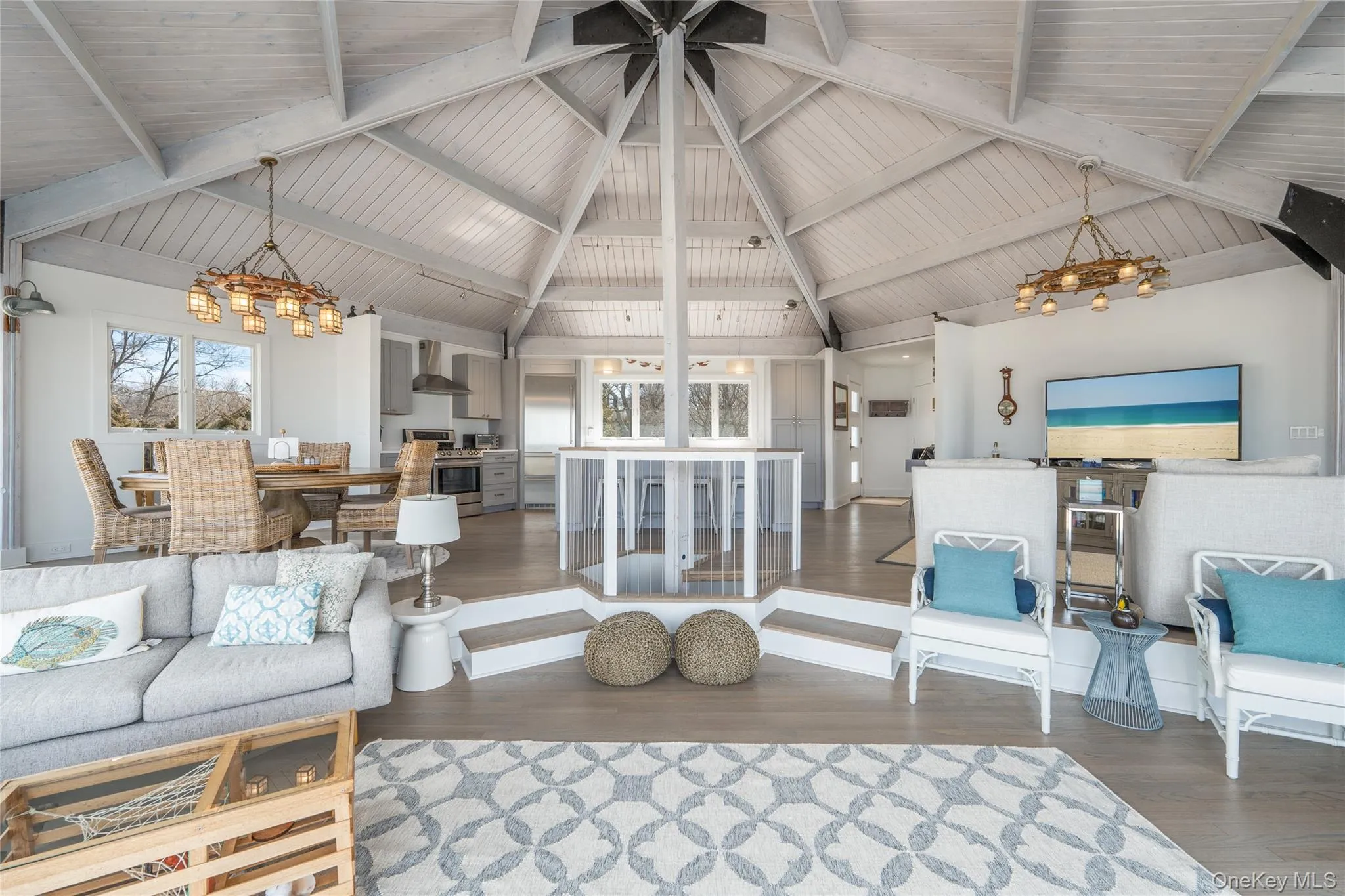 Living room with a notable chandelier, high vaulted ceiling, a healthy amount of sunlight, and wood finished floors Living room with a notable chandelier, high vaulted ceiling, a healthy amount of sunlight, and wood finished floors