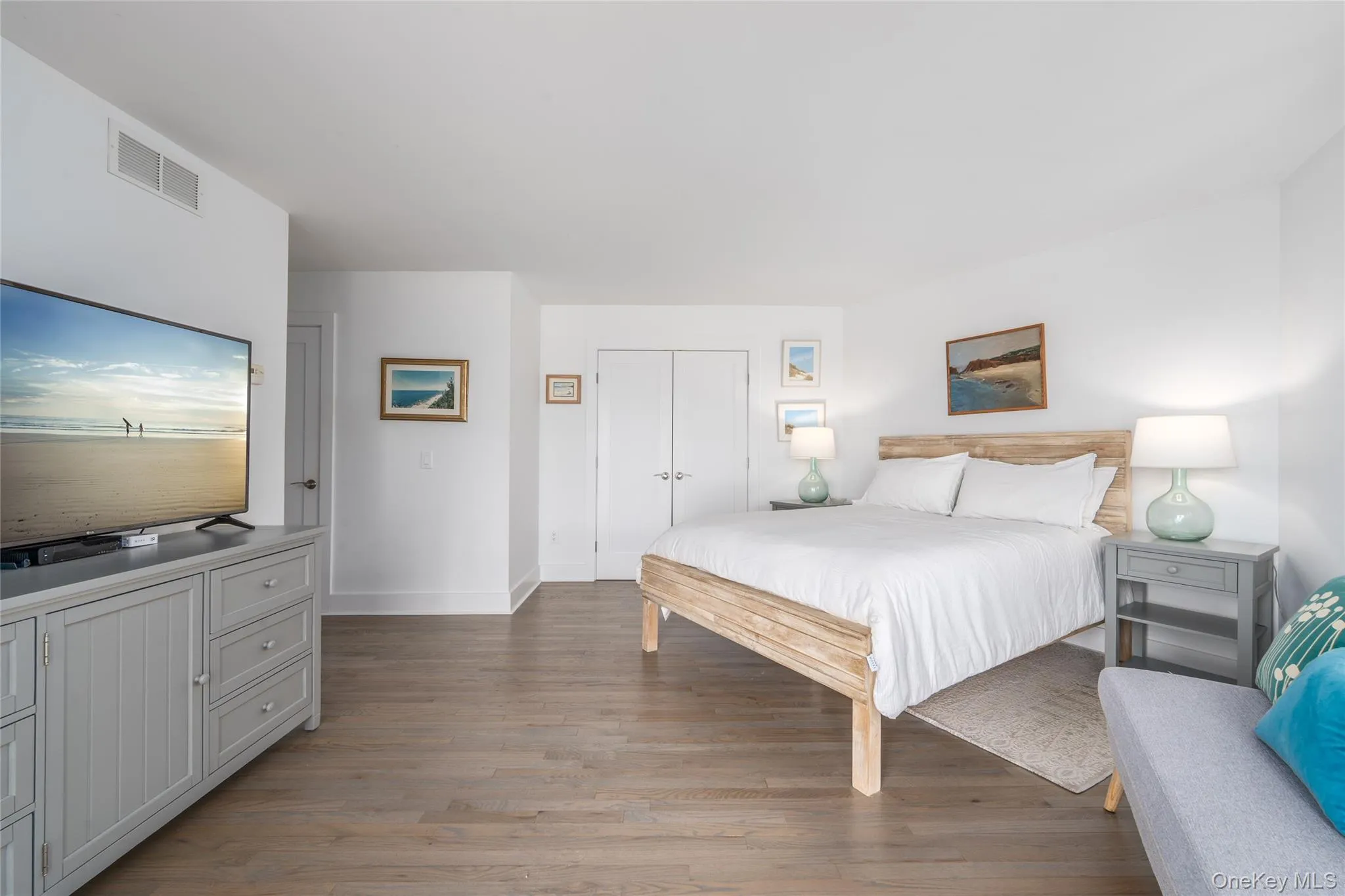 Bedroom with light wood finished floors, baseboards, visible vents, and a closet Bedroom with light wood finished floors, baseboards, visible vents, and a closet