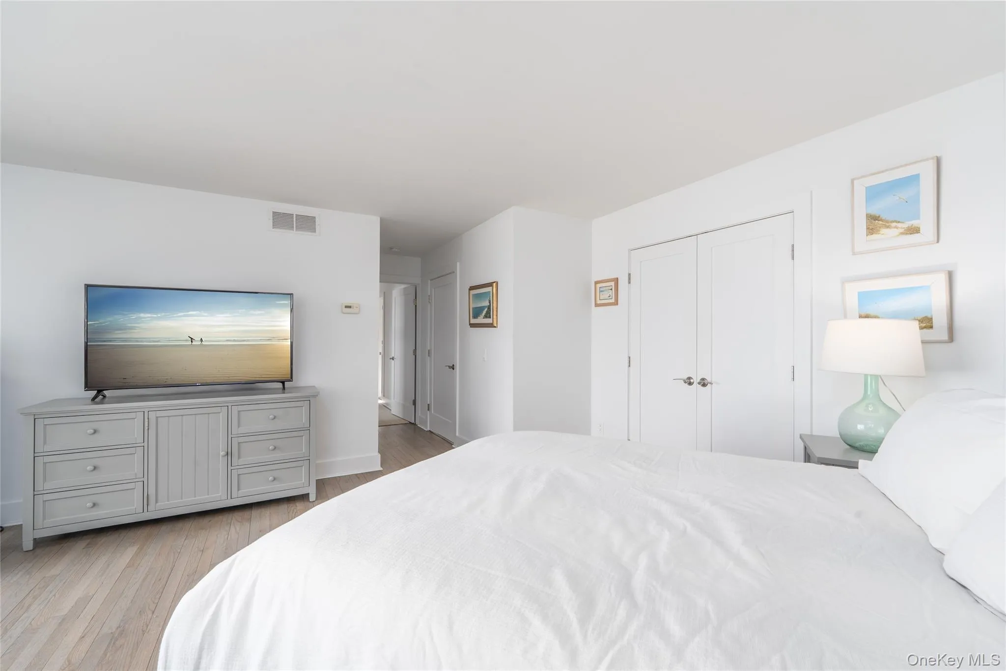Bedroom featuring wood finished floors, baseboards, and visible vents Bedroom featuring wood finished floors, baseboards, and visible vents