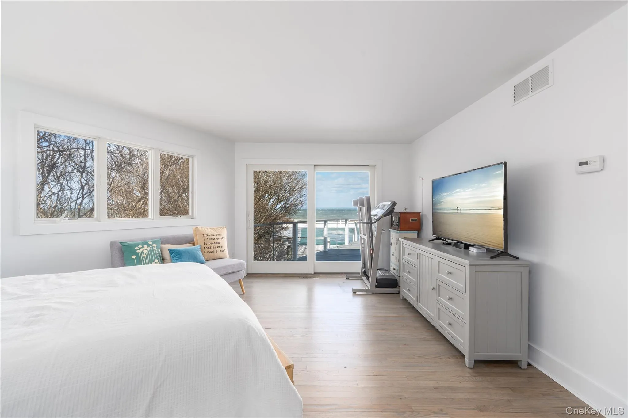 Bedroom with baseboards, visible vents, light wood-type flooring, and access to outside Bedroom with baseboards, visible vents, light wood-type flooring, and access to outside