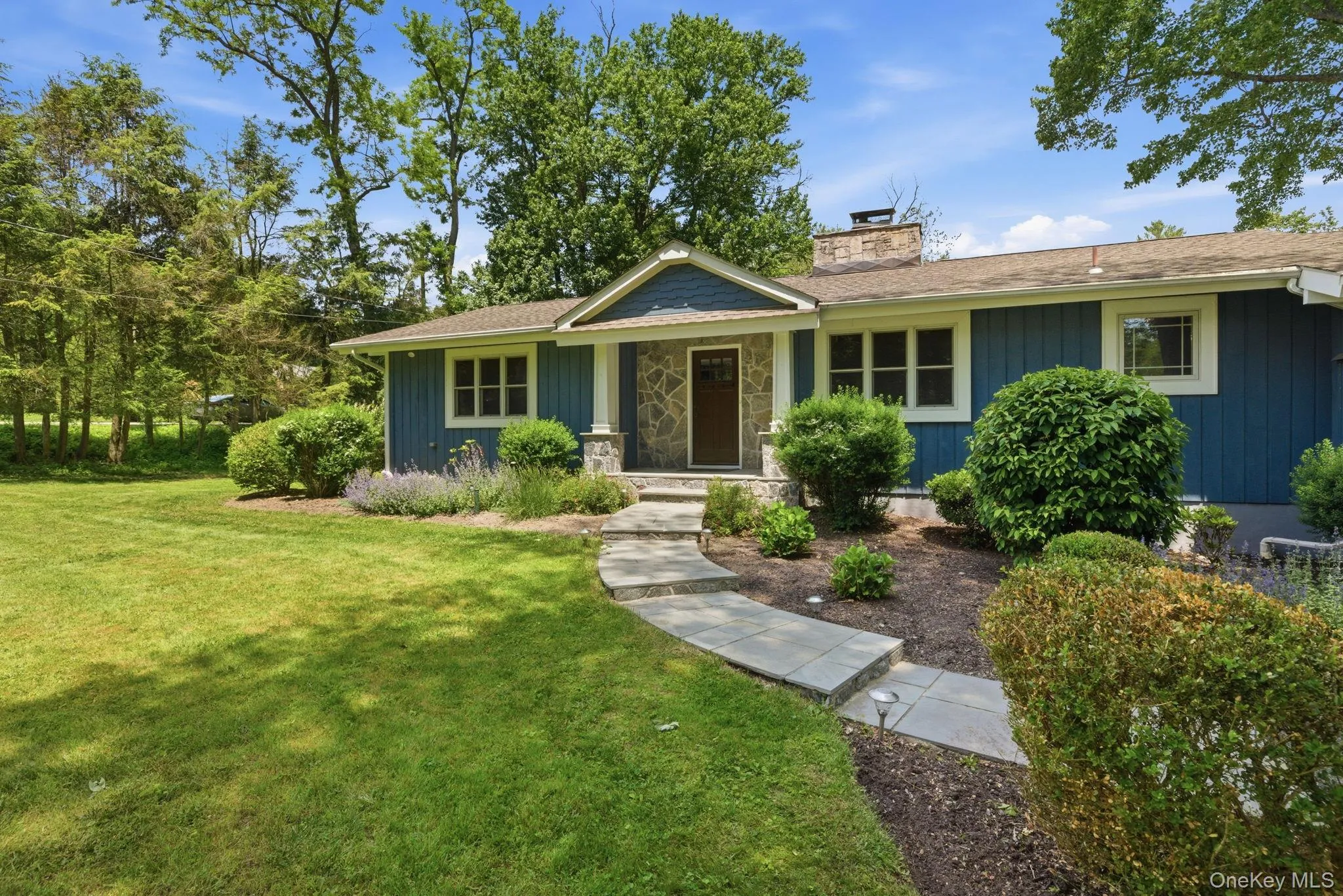 Mature plantings and a winding bluestone path frame this charming Somers ranch in every season. Mature plantings and a winding bluestone path frame this charming Somers ranch in every season.